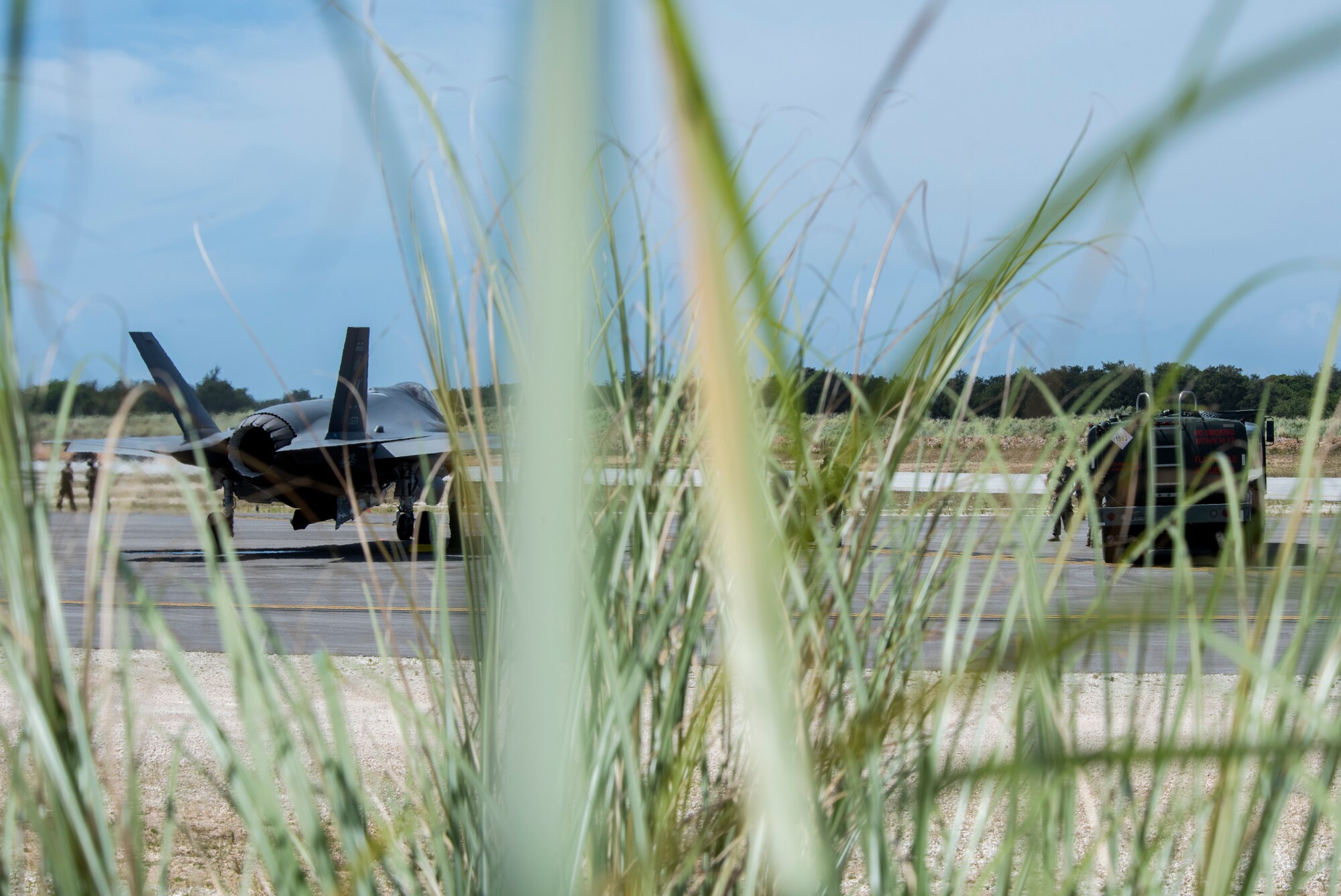 An F-35A Lightning II assigned to Eielson Air Force Base, Alaska, awaits to refuel from an R-11 fuel truck at Northwest Field as part of Agile Combat Employment (ACE) multi-capable Airmen training during Cope North 21 at Andersen AFB, Guam, Feb. 16, 2021.