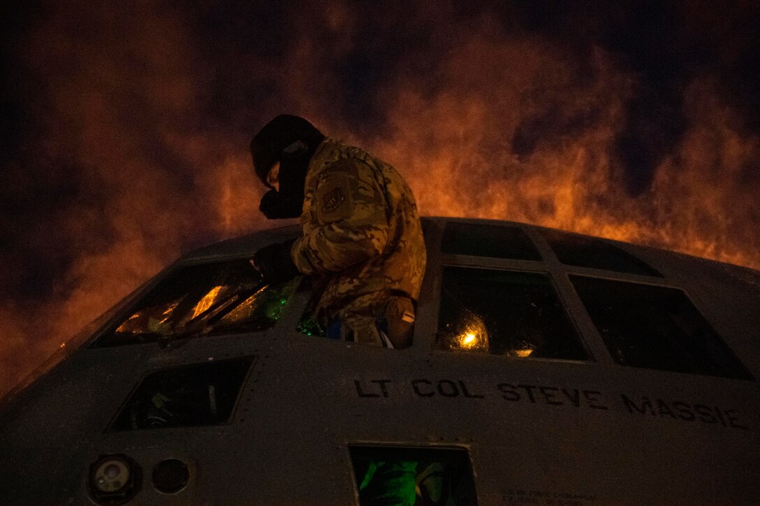U.S. Air Force Staff Sgt. Joel Seifert, 374th Aircraft Maintenance Squadron avionics specialist, scrapes ice off the windows of a C-130J Super Hercules during execution day for exercise Arctic Warrior 21 at Joint Base Elmendorf-Richardson, AK, Feb. 8, 2021