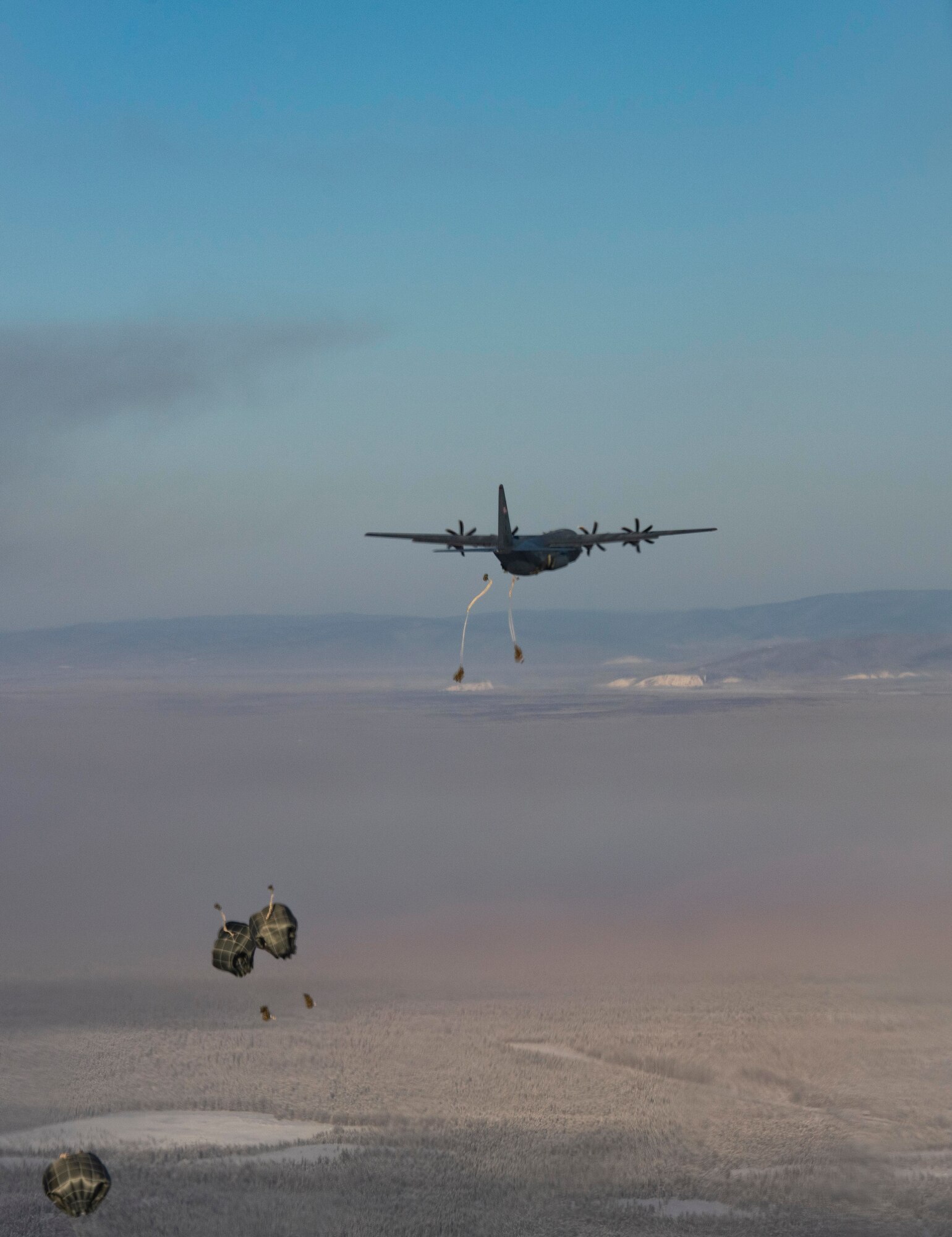 U.S. Army paratroopers, assigned to 3rd Battalion, 509th parachute infantry regiment, 4th Infantry Brigade Combat Team (Airborne), 25th Infantry Division jump out of a C-130J Super Hercules, assigned to the 36th Airlift Squadron, Yokota Air Base, Japan, as part of exercise Arctic Warrior 21 at Donnelly Training Area, AK, Feb. 8, 2021.
