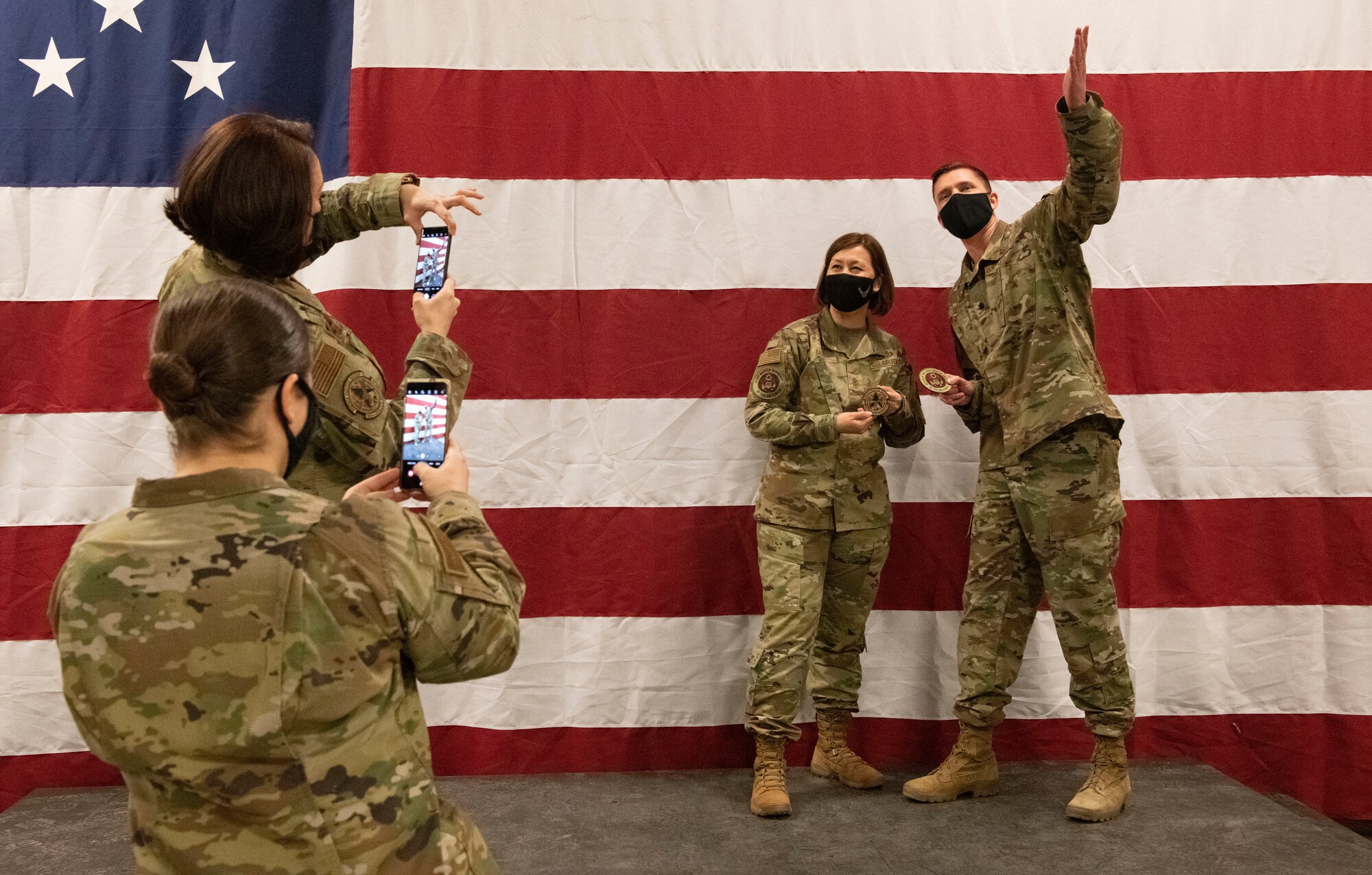 Chief Master Sergeant of the Air Force JoAnne S. Bass poses for a photo with Lt Col. John Henson in front of a United States of America flag.