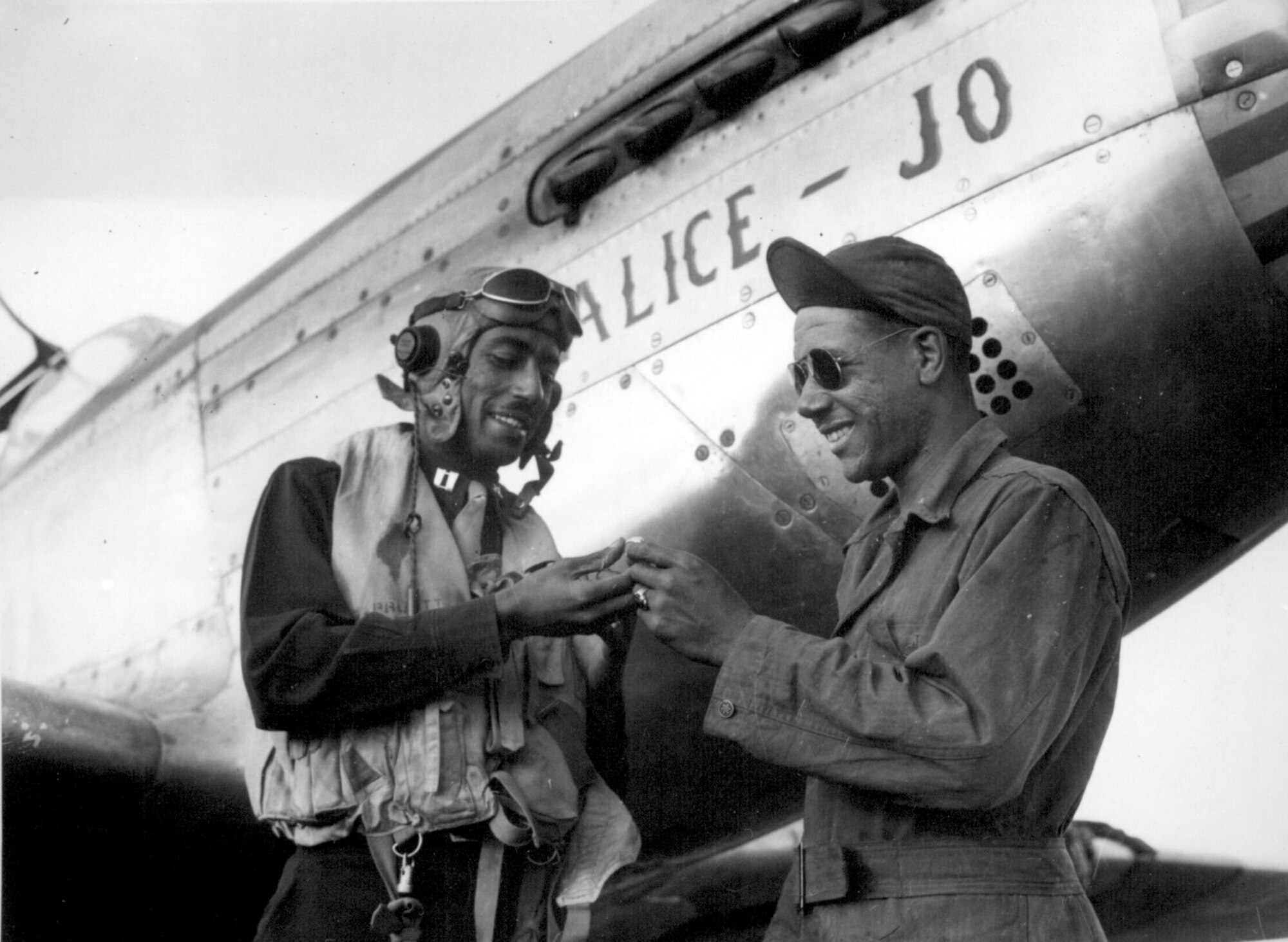 Editor’s note: photo and caption were pulled from the National Archives Catalog.
Capt. Wendell O. Pruitt., one of the leading pilots of the 15th Air Force, always makes sure that he leaves his valuable ring with his crew chief, S/Sgt. Samuel W. Jacobs.                                               Ca. November 1944. 208-AA-46BB-4.