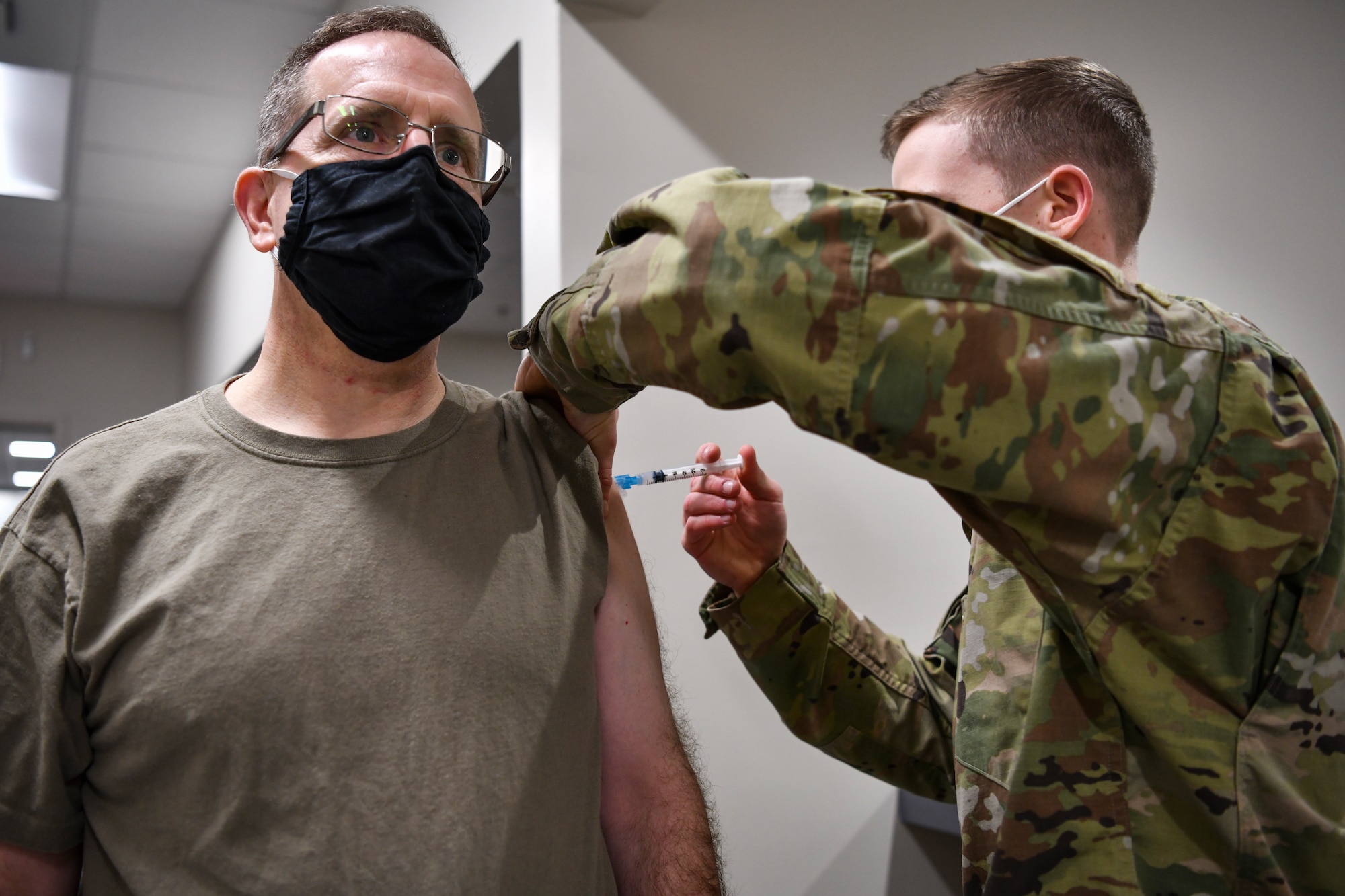 Photo of a medical technician vaccinating Lt. Gen. Jim Slife, commander of Air Force Special Operations Command