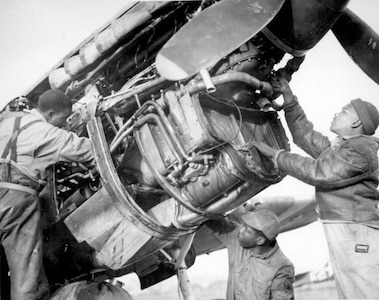 Editor’s note: photo and caption were pulled from the National Archives Catalog.
Sharing credit for Negro fighter pilot’s victory over Nazis are mechanics George Johnson and James C. Howard. Their outfit, the 99th Fighter Squadron, bagged 12 Nazi fighter planes in two days. 
Ca. February 1944. 208-AA-49E-1-1.