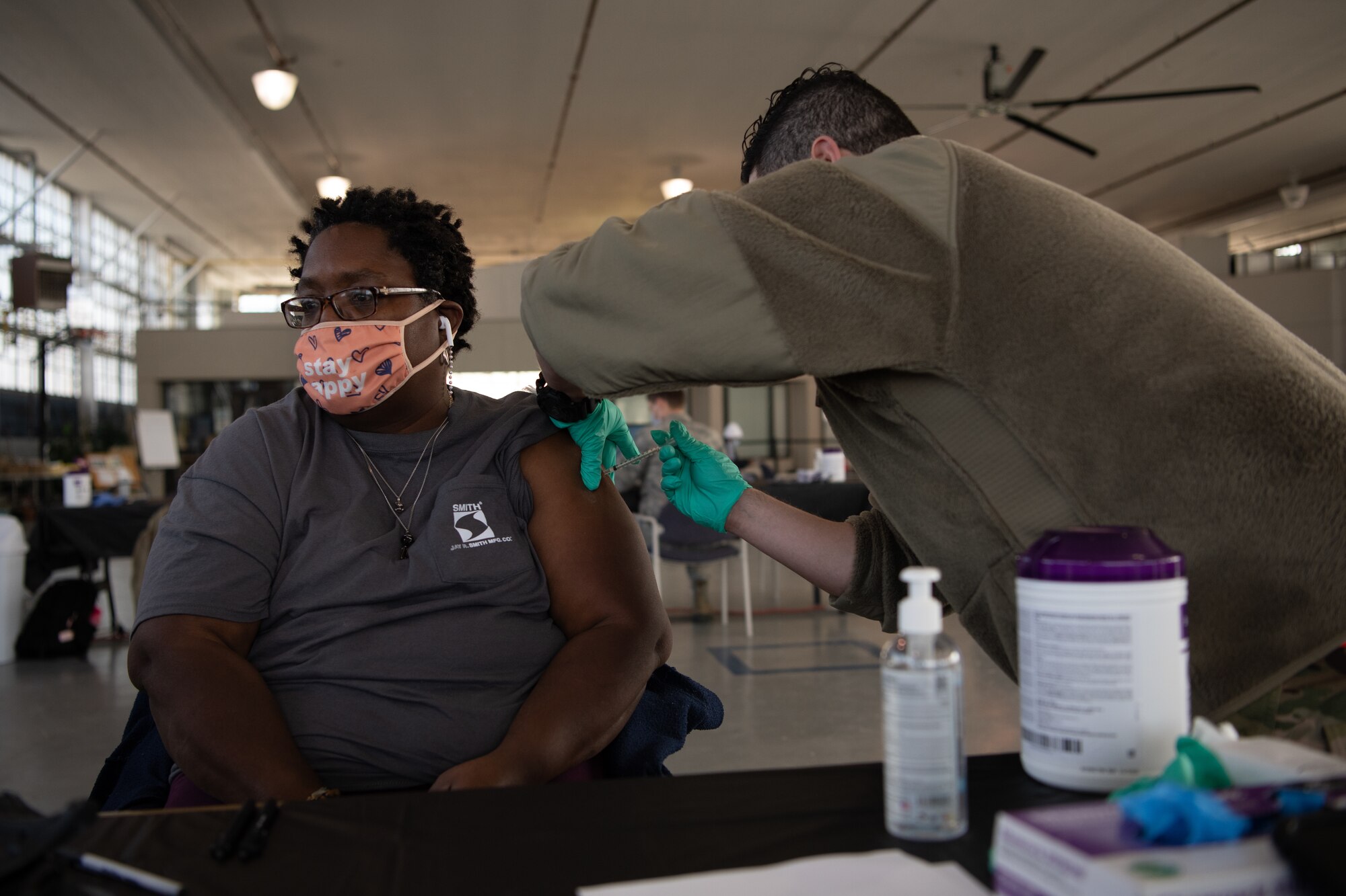 Tech. Sgt. Brandon Avila, 42nd Medical Group Flight Medicine noncommissioned officer in charge, administers the COVID-19 vaccine to Margo Strong, a janitor at the 42nd MDG Jan. 16, 2020, at the off-site clinic in the Honor Guard hangar on Maxwell Air Force Base, Alabama. Strong was offered the vaccine because her job puts her at a higher risk of exposure to COVID-19.