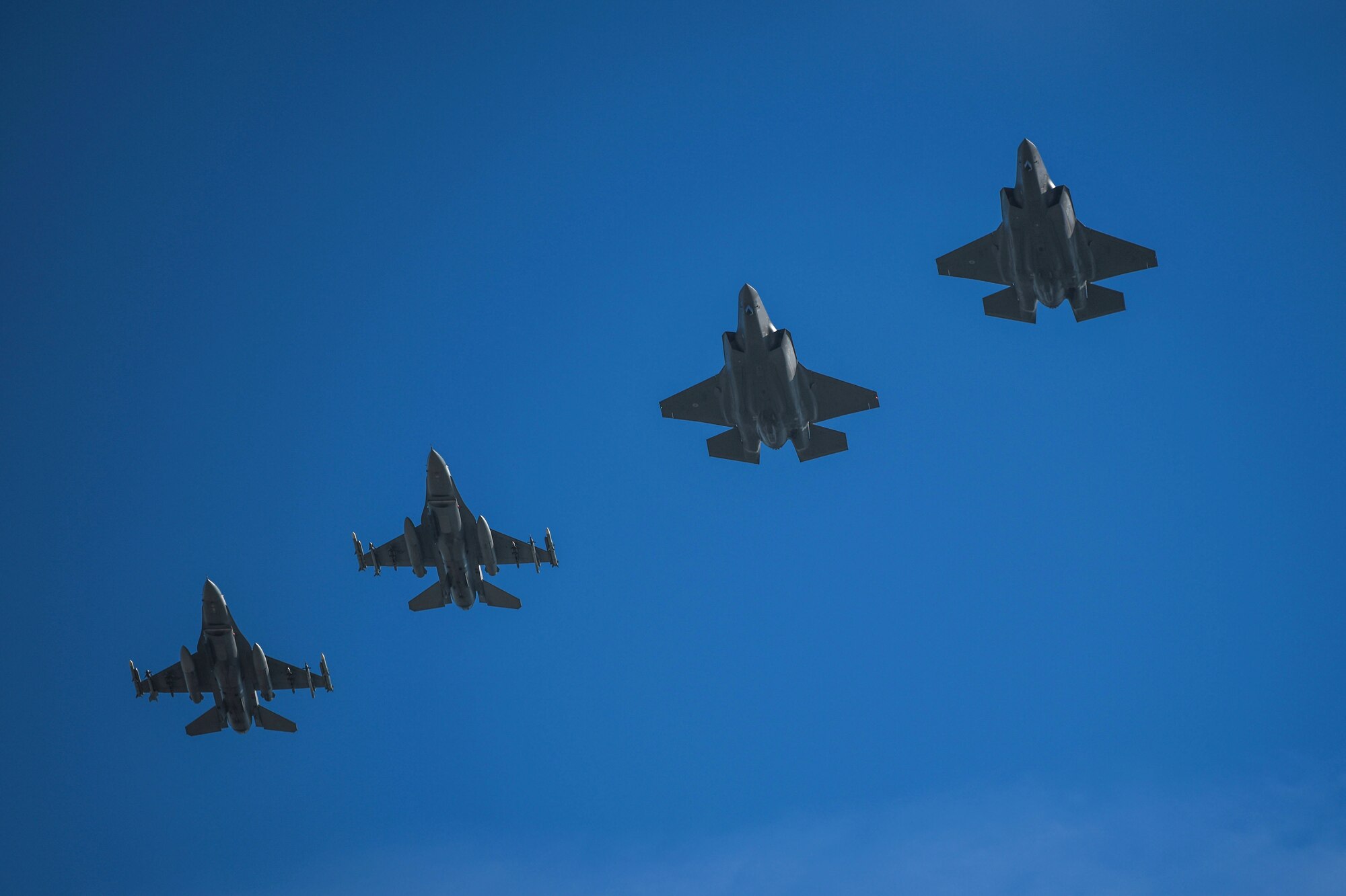 Two U.S. Air Force F-16 Fighting Falcons assigned to the 31st Fighter Wing return from offensive counter air training with two Italian air force F-35 Lightning II assigned to the 32° Stormo during an Agile Combat Employment (ACE) exercise at Amendola Air Base, Italy, Feb. 17, 2021. Training with joint and combined allies and partners during ACE events increases the 31st FW lethality and enhances interoperability, allowing our forces to counter military aggression and coercion by sharing responsibility for common defense. (U.S. Air Force photo by Senior Airman Ericka A. Woolever)