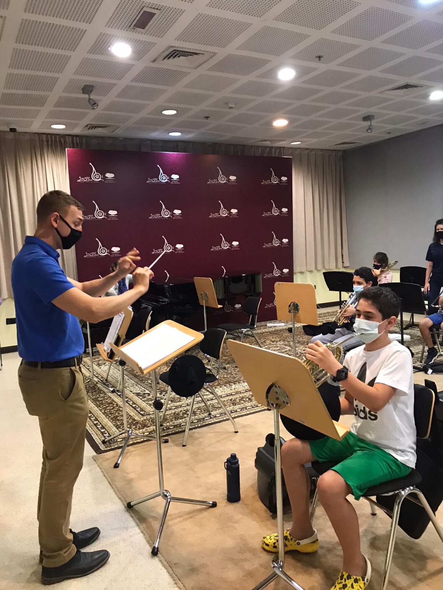 U.S. Air Force Staff Sgt. Michael Coletti, drummer assigned to the U.S. Air Forces Central Band, works with percussion students at the Qatar Music Academy in Doha, Qatar, Feb. 16, 2021.