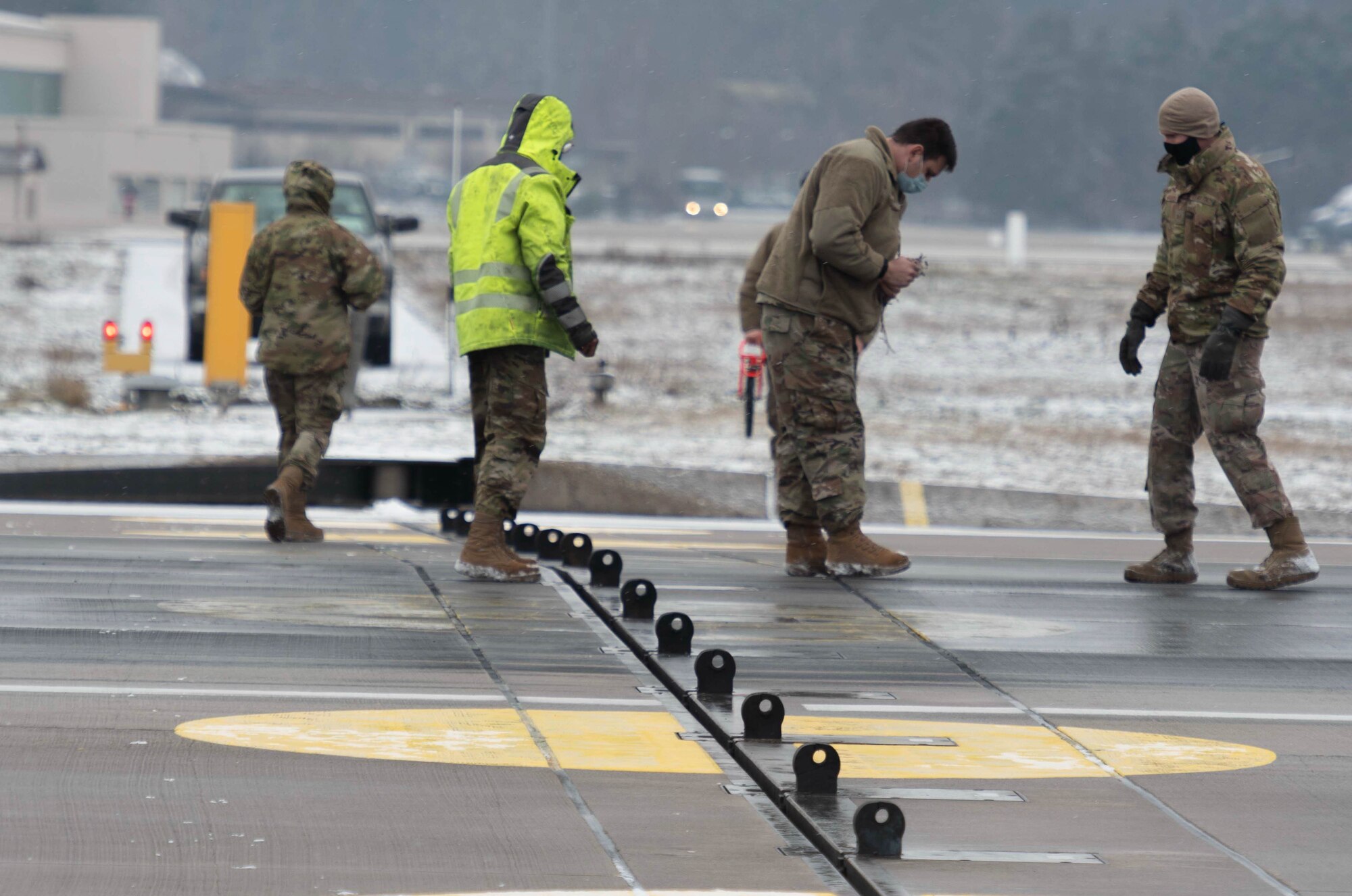 Airmen inspect a barrier arrest system cable during a certification.