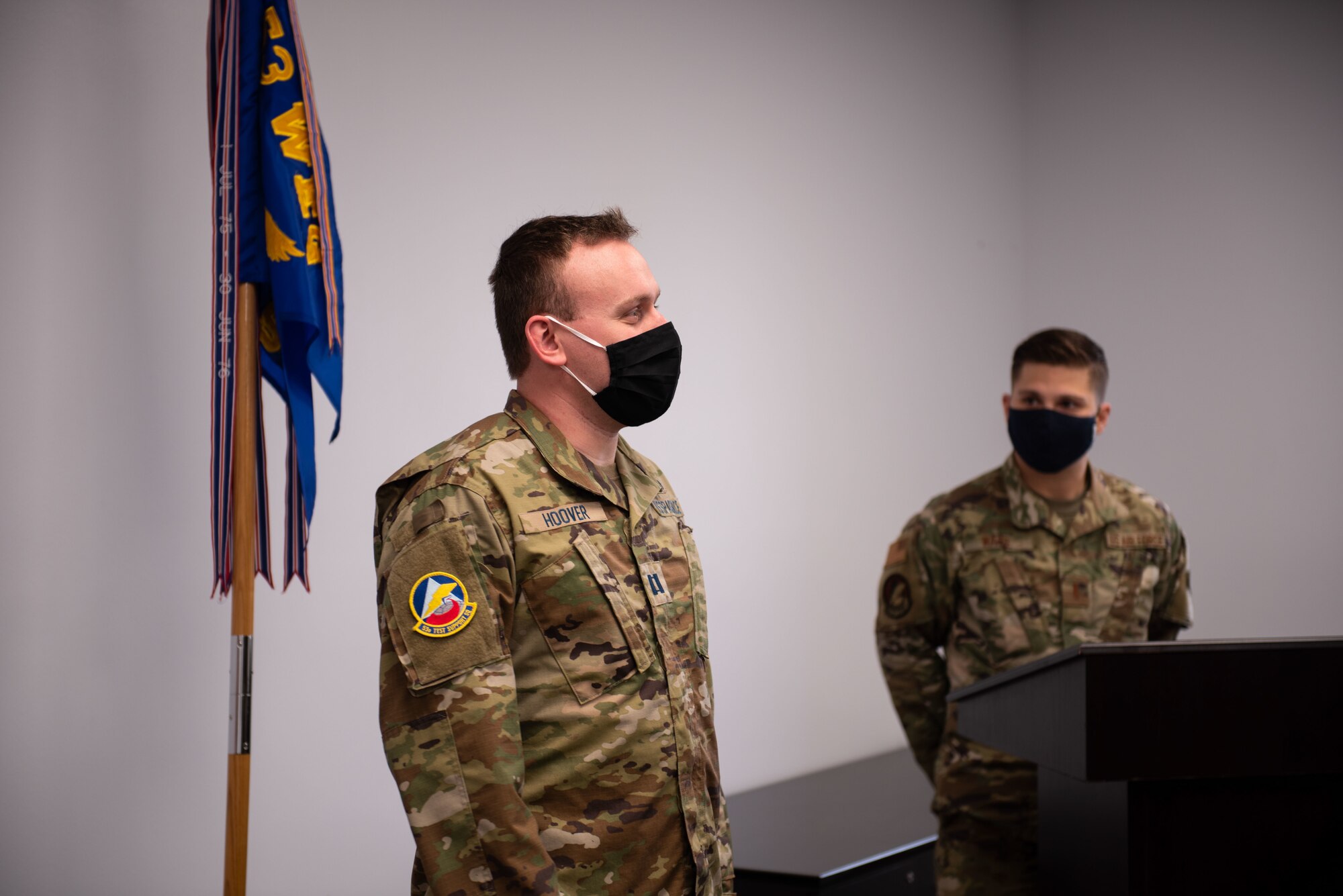 Uniformed member stands to give speech.