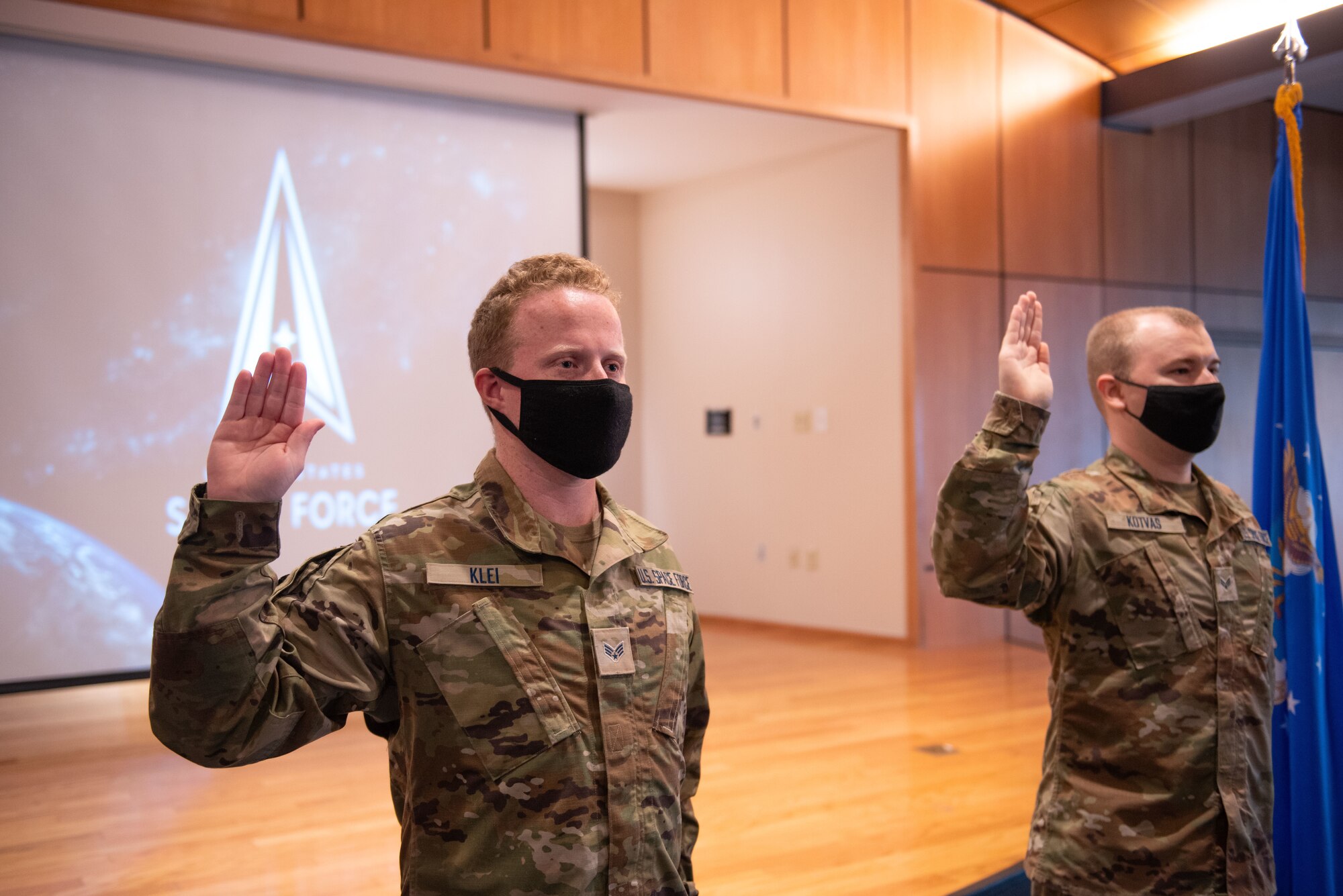 Two uniformed members stand to take an oath