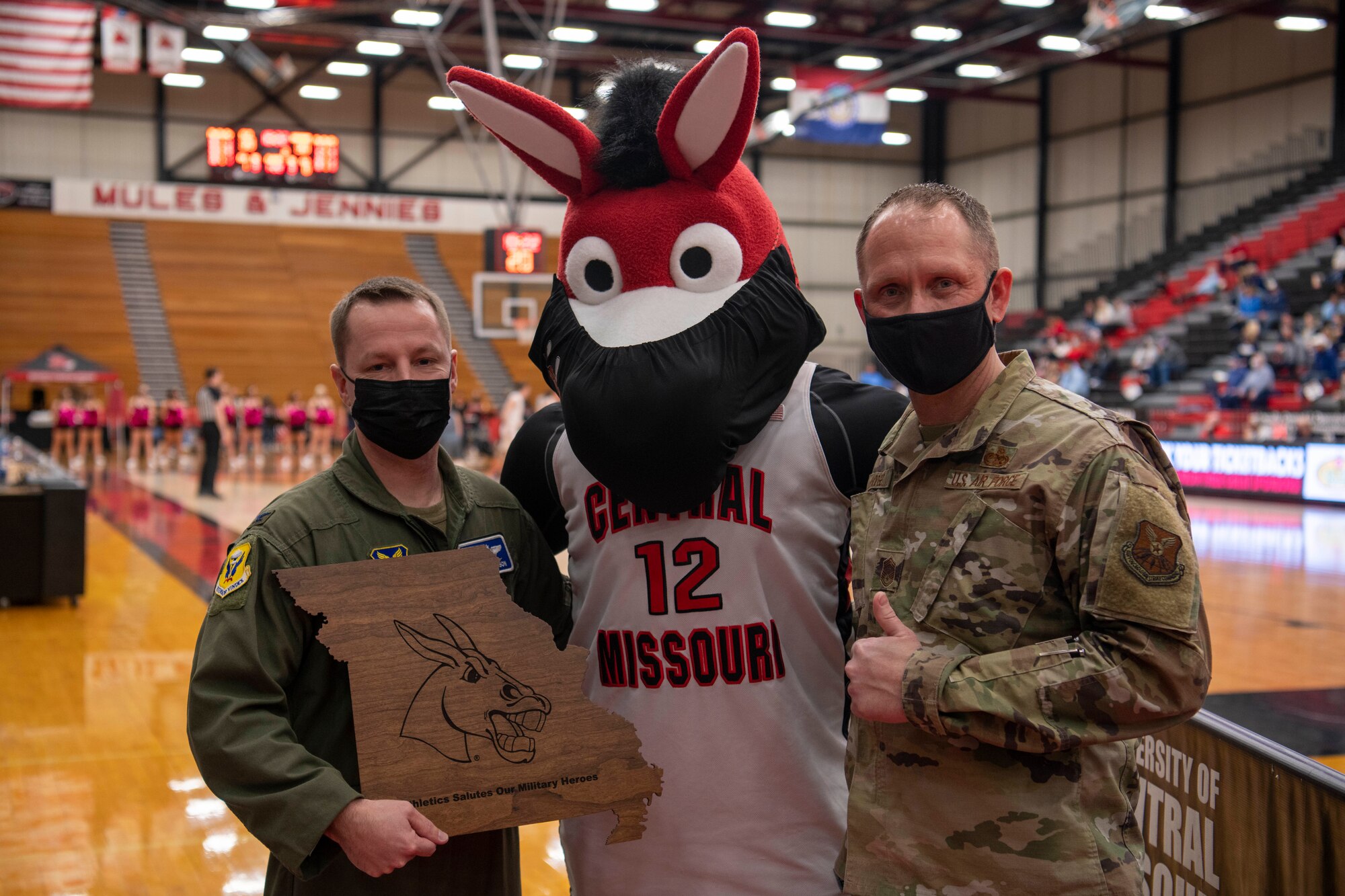 U.S. Air Force Col. Kyle Wilson, 509th Bomb Wing vice commander, left, and Chief Master Sgt. Jason Hodges, 509th BW command chief, right, pose for a photo with the University of Central Missouri mascot during the UCM Military Appreciation basketball game, Feb. 13, 2021, in Warrensburg, Missouri. Whiteman AFB and UCM share a valuable community partnership that fosters a supportive relationship between the base and local communities. (U.S. Air Force photo by Tech. Sgt. Dylan Nuckolls)