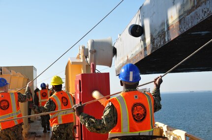 Sailors from Navy Cargo Handling Battalion 1 (NCHB 1) swing literage aboard the USNS 1st LT Jack Lummus (T-AK 3010) during an instream loading exercise.