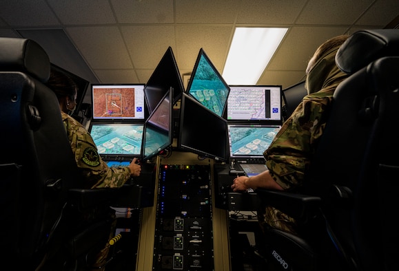 Capt. Sophie, left, 20th Attack Squadron pilot, and Staff Sgt. Timothy, 20th ATKS sensor operator, fly a sortie via simulator at Whiteman Air Force Base, Mo., Nov. 20, 2020. The 20th ATKS is a geographically separated unit under the 432nd Wing and 432nd Air Expeditionary Wing. (U.S. Air Force photo by Airman 1st Class William Rio Rosado)