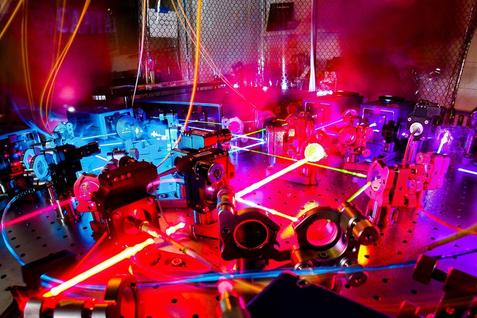 A large room filled with equipment is bathed in colorful lights.