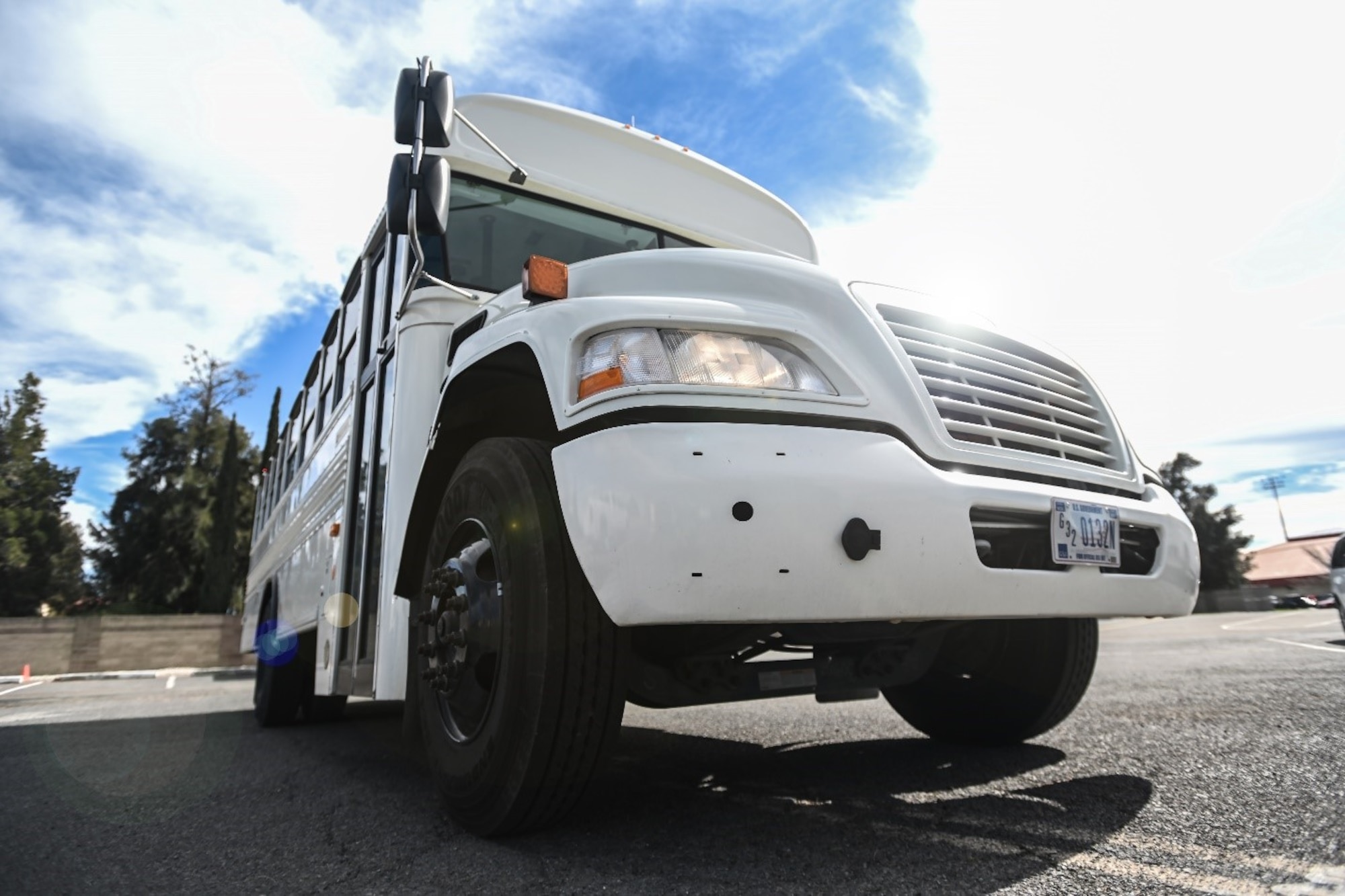 A bus is parked in a parking lot. It's mid-day
