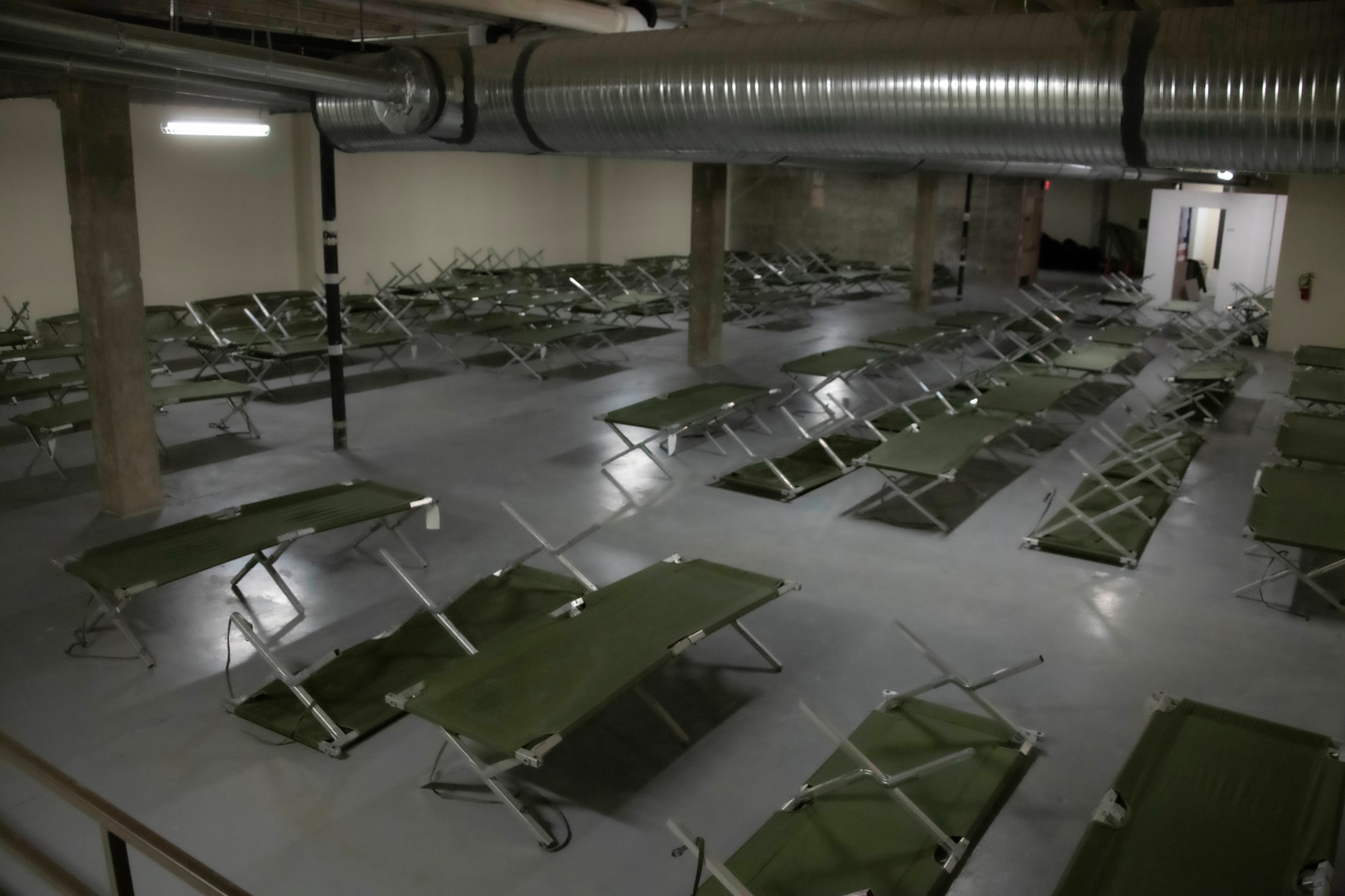 Sleeping cots are laid out in a room