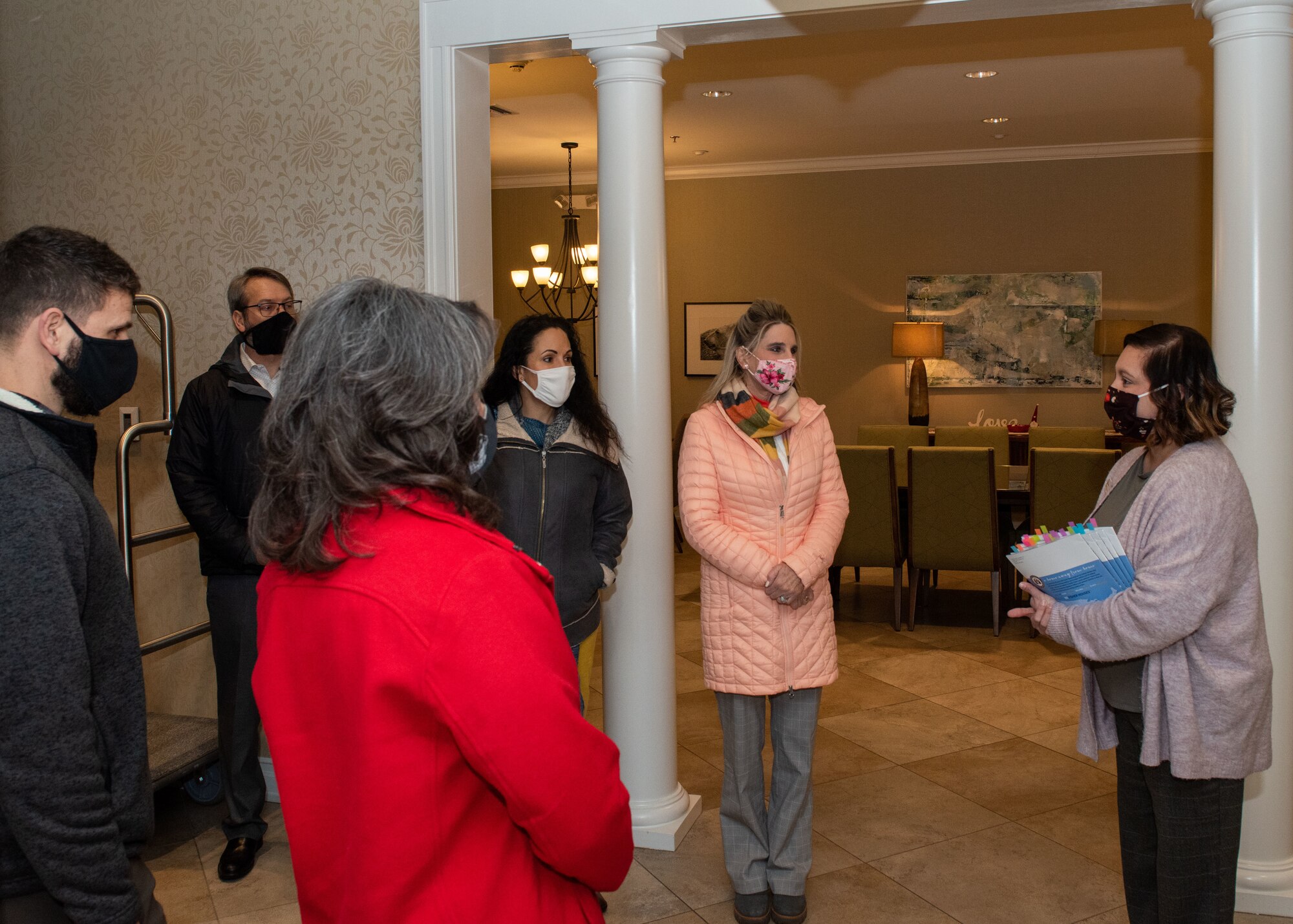 Theresa Nedrow, right, Alaska Fisher House interim manager, briefs Cindy Wilsbach, second from right, wife of the Pacific Air Forces commander, and other PACAF and Joint Base Elmendorf-Richardson senior leaders’ spouses during a visit to Fisher House II at JBER, Alaska, Feb. 16, 2021. Fisher House II opened in September 2018 and features 16 suites with private bedrooms and baths, and includes a common kitchen, dining room, living room and laundry facilities. Fisher Houses provide free accommodation for families of patients receiving care at major military and Veterans Affairs medical centers.