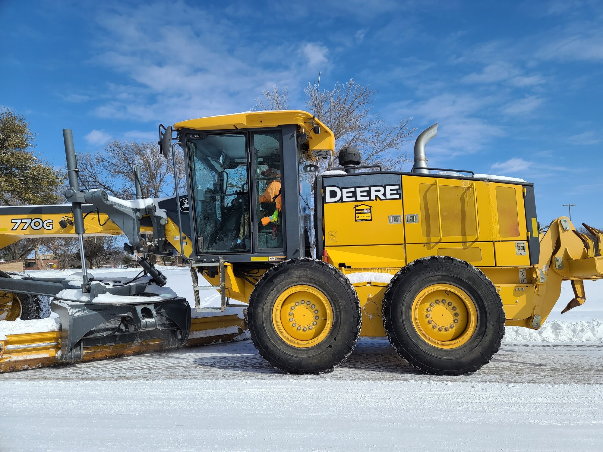 A member of the snow removal team plows the troop walk on Goodfellow Air Force Base, Texas, Feb. 15, 2021. The base rented a grader from downtown to remove the snow from roads across the installation. (U.S. Air Force photo by Airman 1st Class Michael Bowman)
