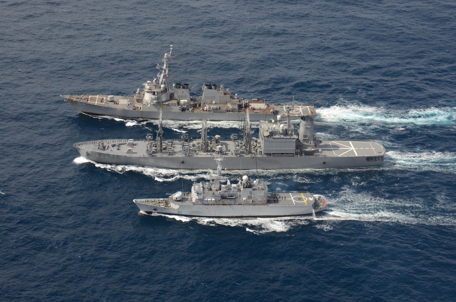 The Arleigh Burke-class guided-missile destroyer USS Curtis Wilbur (DDG 54) conducts a replenishment-at-sea with the Japan Maritime Self-Defense Force Towada-class replenishment ship JS Hamana (AOE 424) and French Floreal-class light frigate FNS Prairial (F731).
