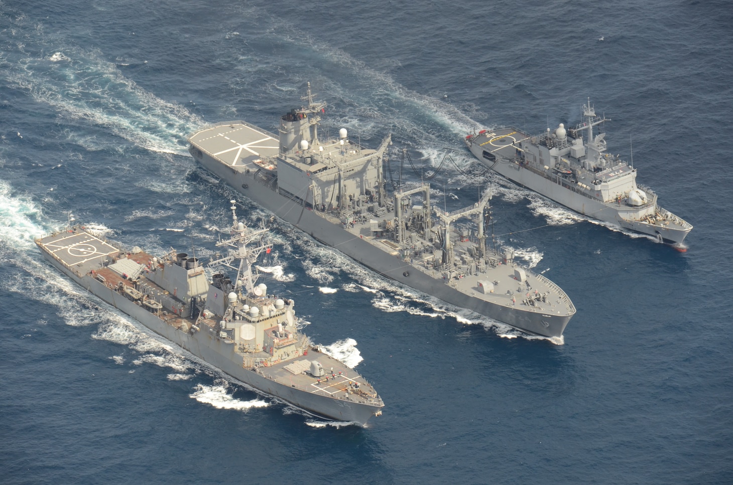 The Arleigh Burke-class guided-missile destroyer USS Curtis Wilbur (DDG 54) conducts a replenishment-at-sea with the Japan Maritime Self-Defense Force Towada-class replenishment ship JS Hamana (AOE 424) and French Floreal-class light frigate FNS Prairial (F731).