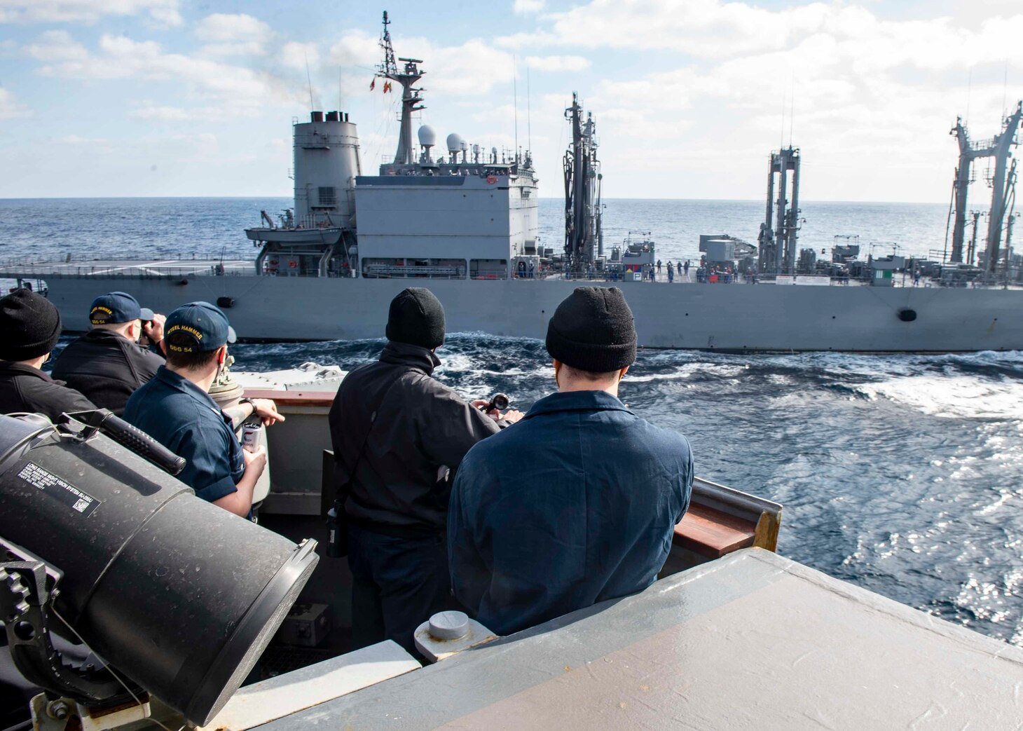 Sailors aboard the Arleigh Burke-class guided-missile destroyer USS Curtis Wilbur (DDG 54) man the bridge wing prior to a replenishment-at-sea with the Japanese Towada-class replenishment ship JS Hamana (AOE 424). Curtis Wilbur is assigned to Destroyer Squadron (DESRON) 15, the Navy's largest forward-deployed DESRON and the U.S. 7th Fleet's principal surface force.