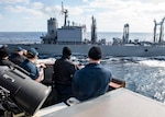 Sailors aboard the Arleigh Burke-class guided-missile destroyer USS Curtis Wilbur (DDG 54) man the bridge wing prior to a replenishment-at-sea with the Japanese Towada-class replenishment ship JS Hamana (AOE 424). Curtis Wilbur is assigned to Destroyer Squadron (DESRON) 15, the Navy's largest forward-deployed DESRON and the U.S. 7th Fleet's principal surface force.