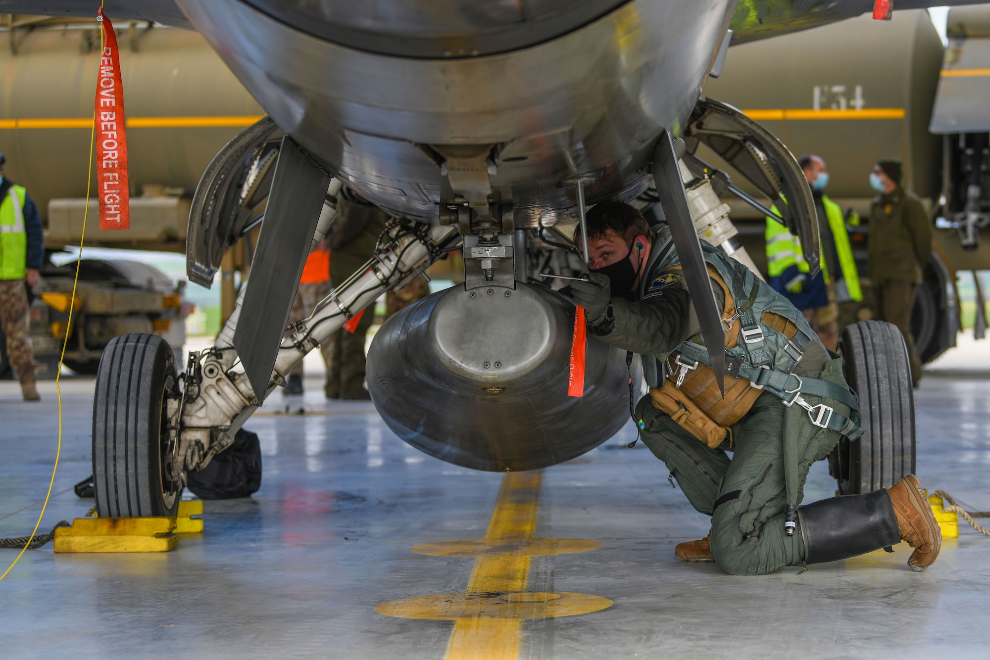U.S. Air Force 1st Lt. Kyle Senn, 555th Fighter Squadron pilot, pins a warning tag onto an F-16 Fighting Falcon during an Agile Combat Employment exercise at Amendola Air Base, Italy, Feb. 16, 2021. ACE exercises are designed to ensure U.S. Air Forces in Europe, along with allies and partners, are ready for potential short or no-notice contingencies. (U.S. Air Force photo by Senior Airman Ericka A. Woolever)