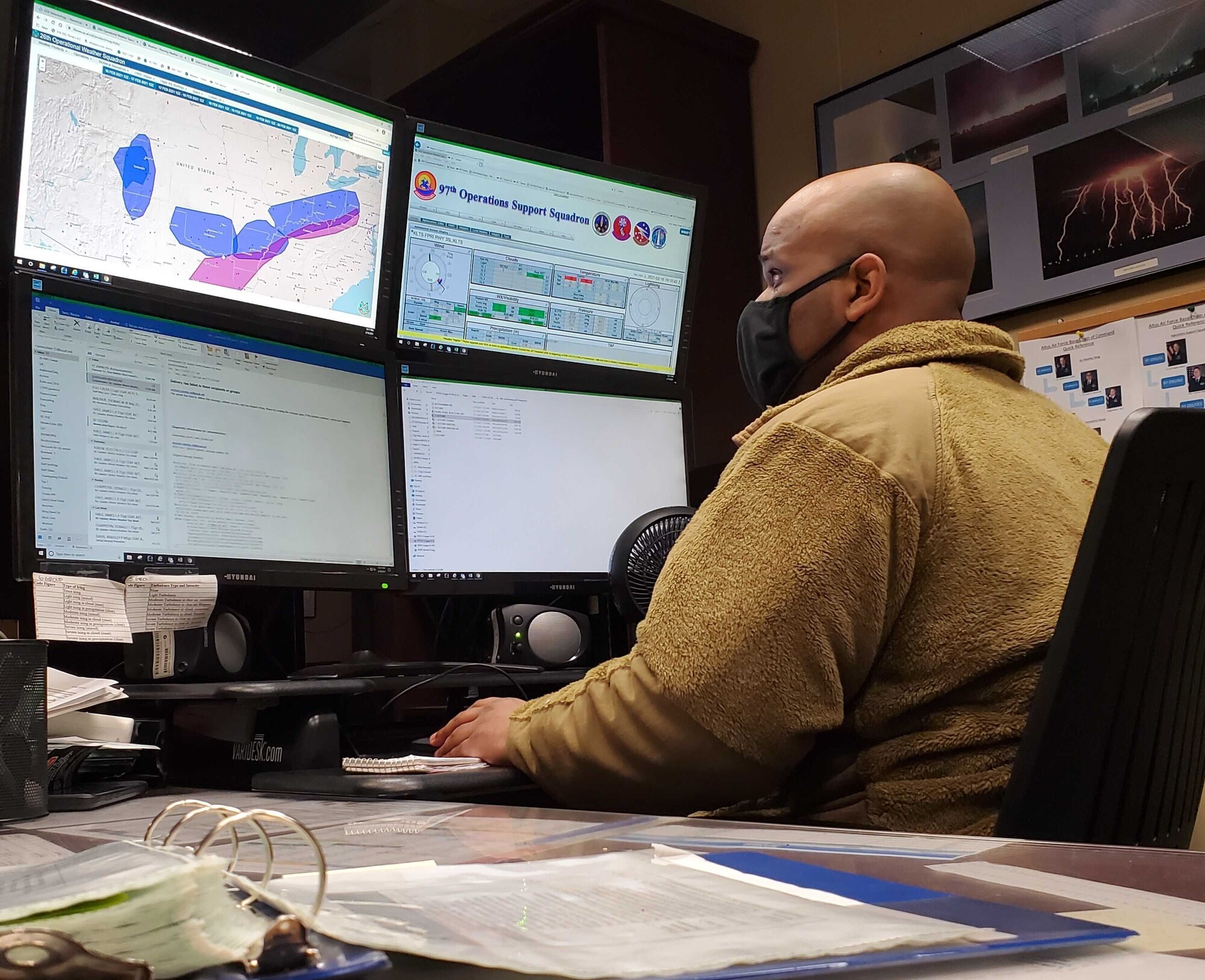 person looks at multiple computer monitors