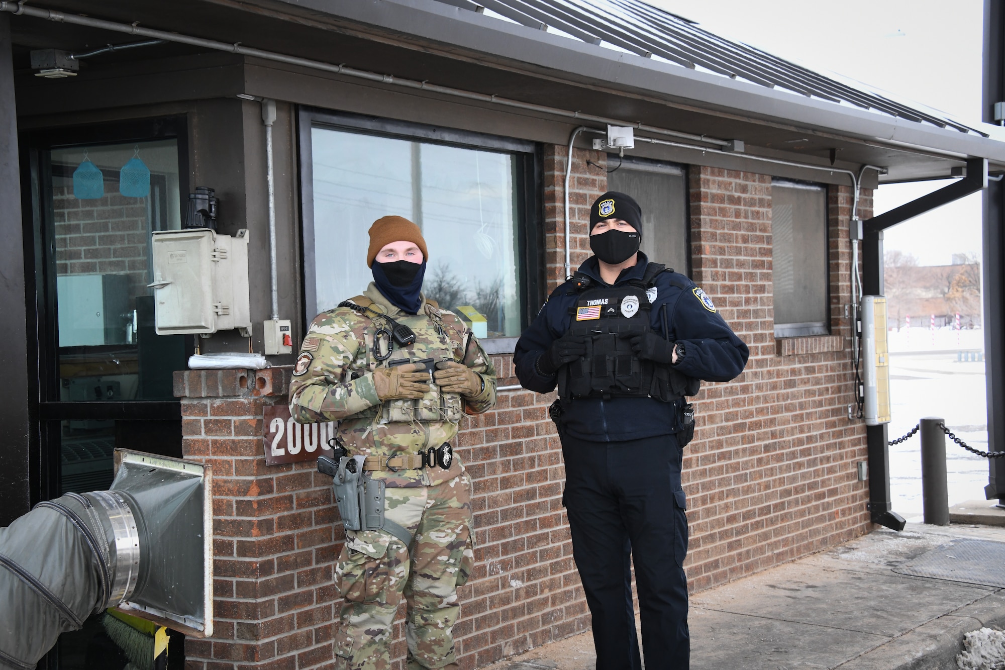 From left, Airman 1st Class Seth Chaffee, 97th Security Forces squadron force protection specialist, and Danny Thomas, 97th SFS flight sergeant, defend the main gate, Feb. 16, 2021, at Altus Air Force Base, Oklahoma. Working in 12-hour shifts during a weather emergency, security forces Airmen protected the base and kept Airmen and their families safe. (U.S. Air Force photo by Airman 1st Class Kayla Christenson)