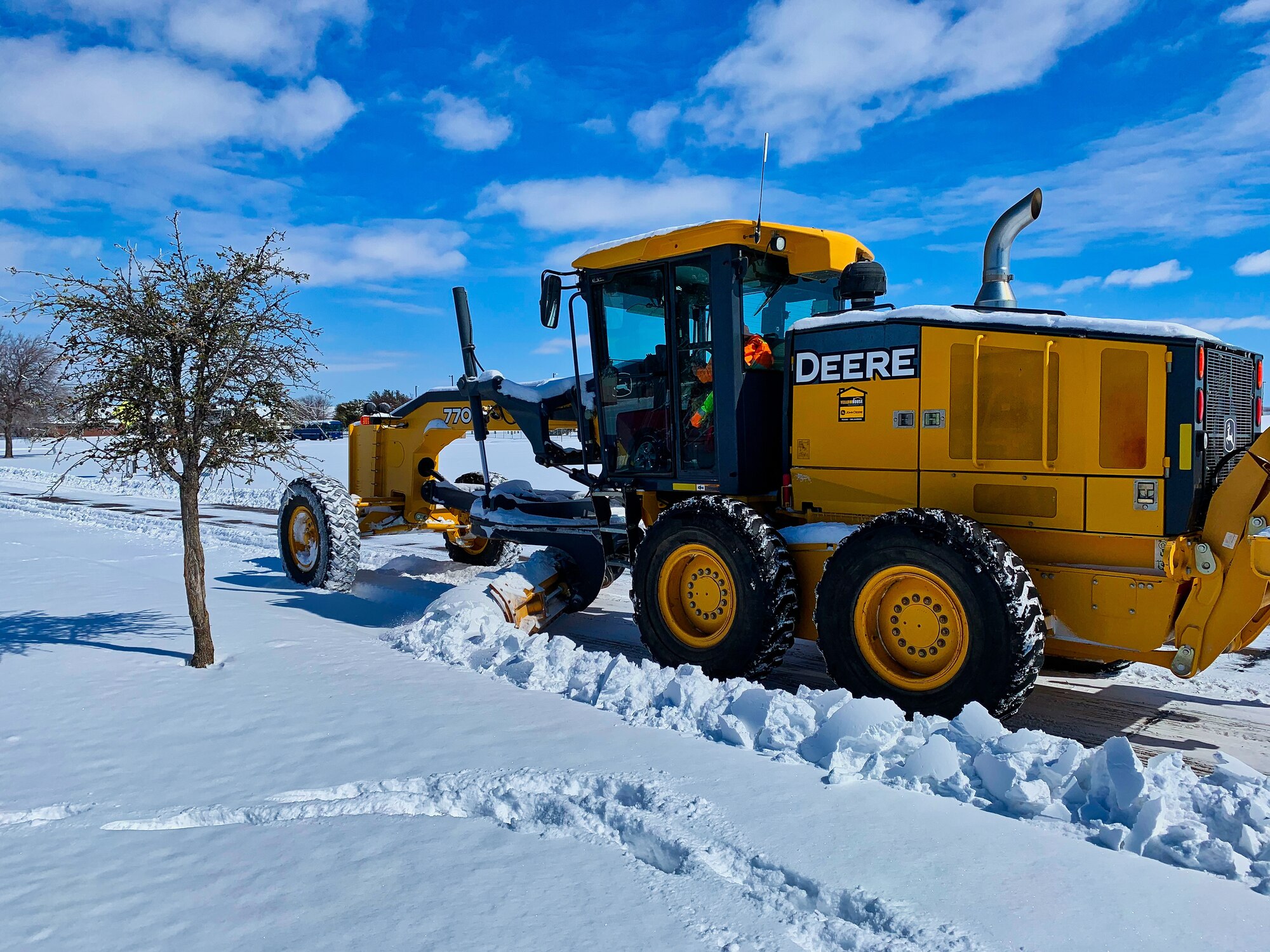 A member of the 17th Civil Engineering Squadron enhances the safety of the travel routes throughout the base by clearing snow on Goodfellow Air Force Base, Texas, Feb. 15, 2021. The 17th CES adapted and overcame the challenges of record-breaking snowfall with no proper removal equipment in order to continue the mission. (Courtesy photo)