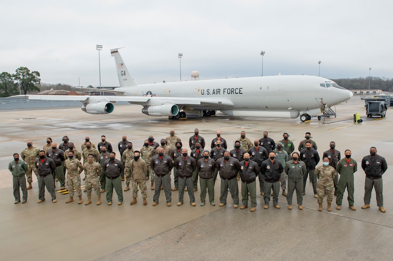 Photo shows group of Airmen standing in front of aircraft.
