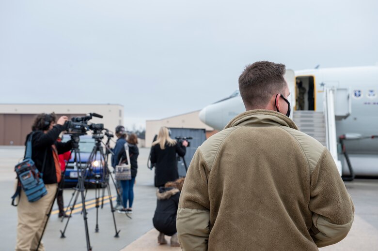 Photo shows people with cameras on tripods pointed toward aircraft.