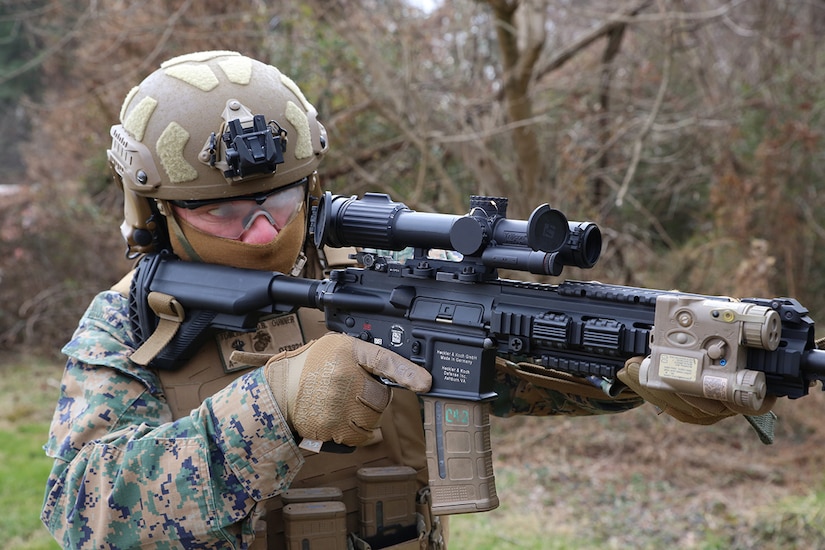 A sailor looks through the scope of a weapon.
