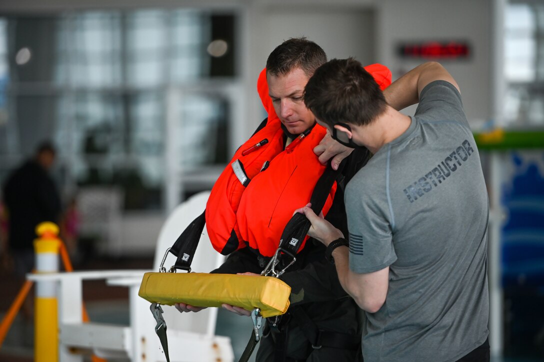 A 388th Fighter Wing water survival training instructor attaches a harness to Lt. Col. Bart Wilbanks, an F-35A Lightning II pilot in the 419th Fighter Wing at Hill Air Force Base, Utah, as part of water survival training refresher course.