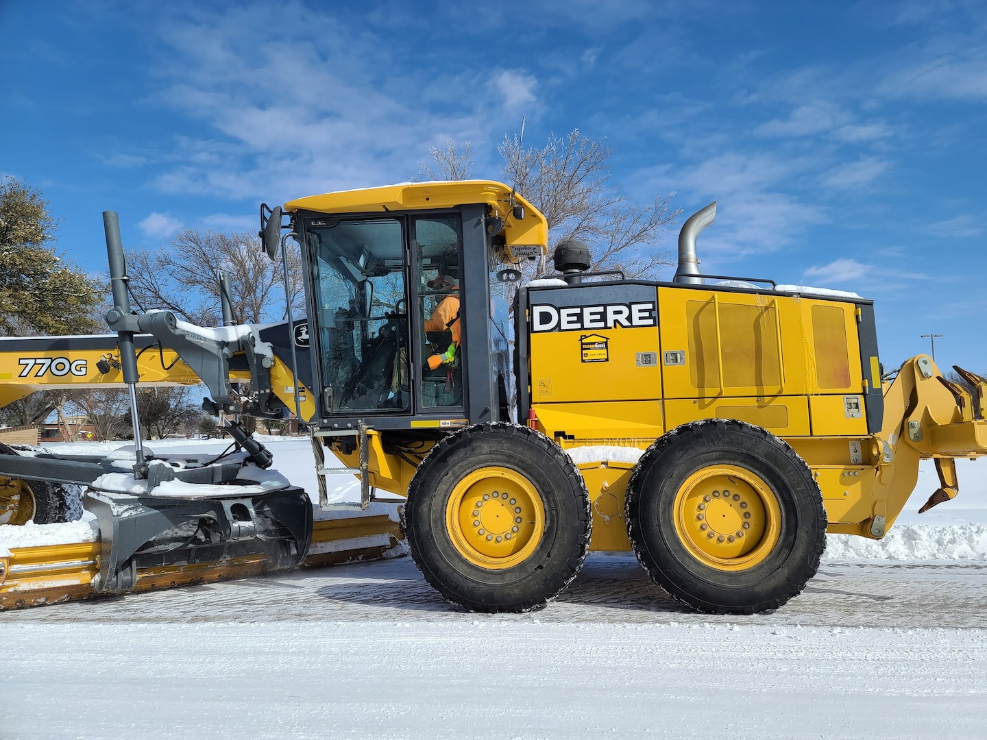 A member of the snow removal team plows the troop walk on Goodfellow Air Force Base, Texas, Feb. 15, 2021. The base rented a grader from downtown to remove the snow from roads across the installation. (U.S. Air Force photo by Airman 1st Class Michael Bowman)