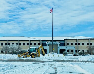 A member of the 17th Civil Engineering Squadron clears snow in front of the Norma Brown building on Goodfellow Air Force Base, Texas, Feb. 15, 2021. The base experienced freezing temperatures and heavy snowfalls, but when faced with these challenges, Team Goodfellow thrived and overcame the obstacles. (Courtesy photo)