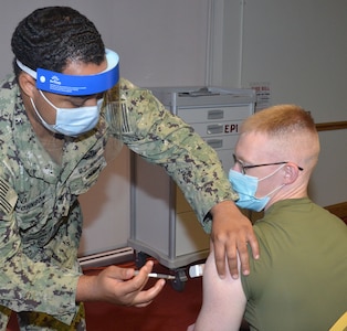 A service member gets a vaccination.