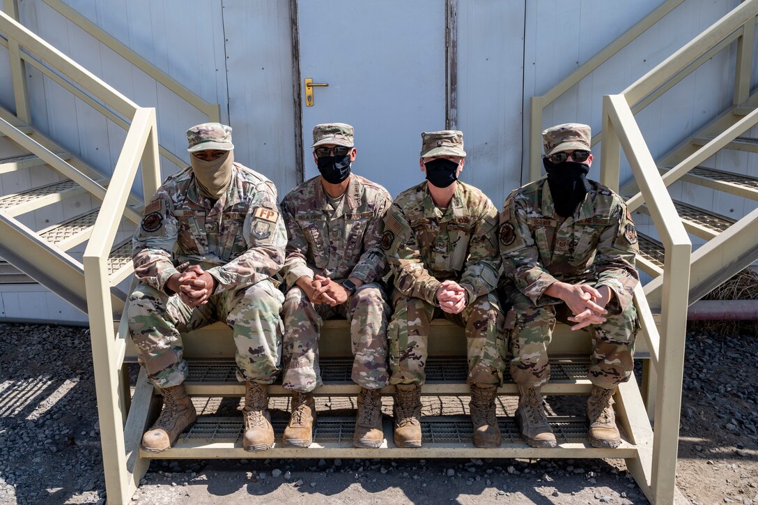 U.S. Air Force Staff Sgt. Ian Shine (far left) and Tech. Sgt. Heidi Beckman (far right) assigned to the 380th Expeditionary Security Forces Squadron, and Tech. Sgt. Teodorico Dela Cruz (center left) and Tech. Sgt. Samantha Tremblay (center right) assigned to the 380th Expeditionary Civil Engineer Squadron, pose for a photo at Al Dhafra Air Base, United Arab Emirates, Feb. 17, 2021.