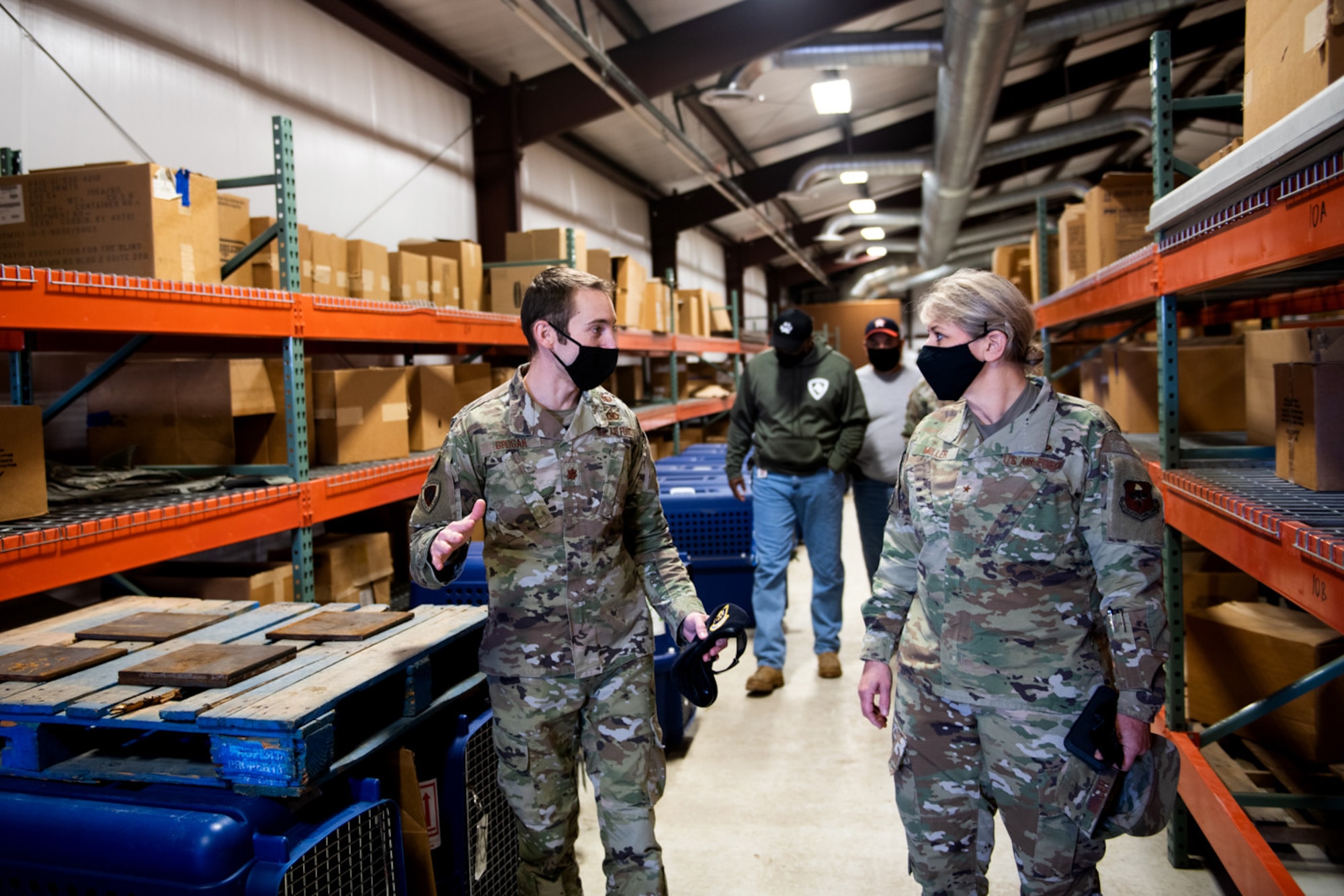 U.S. Air Force Brig. Gen. Caroline Miller (right), 502nd Air Base Wing and Joint Base San Antonio commander, receives a tour from Maj. Tate Grogan (left), 341st Training Squadron director of operations, of where K-9 were stored during the cold weather Feb. 19, 2021, at Joint Base San Antonio, Texas.