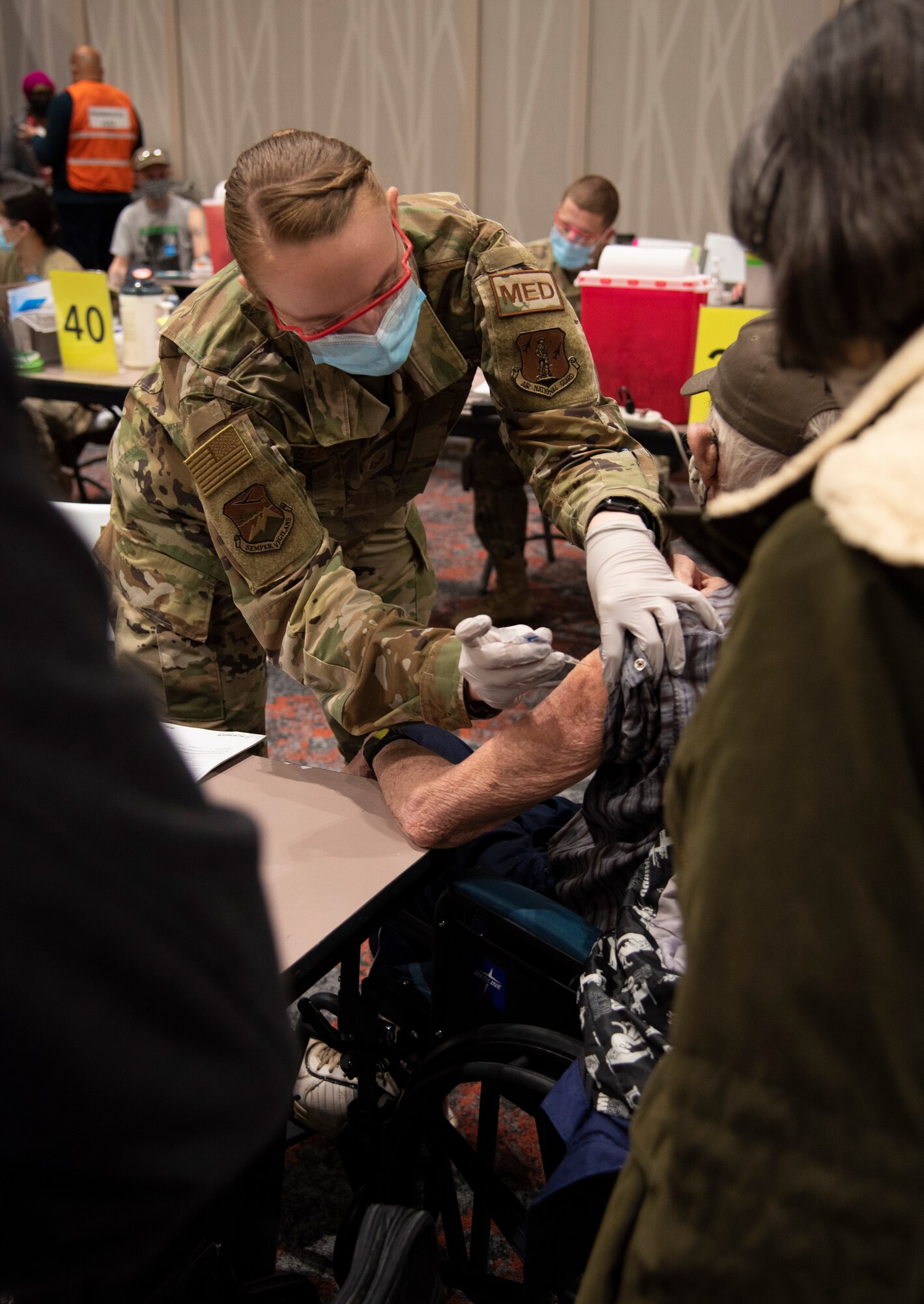 U.S. Air Force Tech. Sgt. Holley Bergfeld, a medic with the 142nd Medical Group, administers a COVID-19 vaccine at the Portland Convention Center, Portland, Ore., February 18, 2021. Members of the Oregon Air and Army National Guard are helping to facilitate COVID-19 vaccination distribution efforts throughout the state. (U.S. Air National Guard photo by Tech. Sgt. Steph Sawyer)