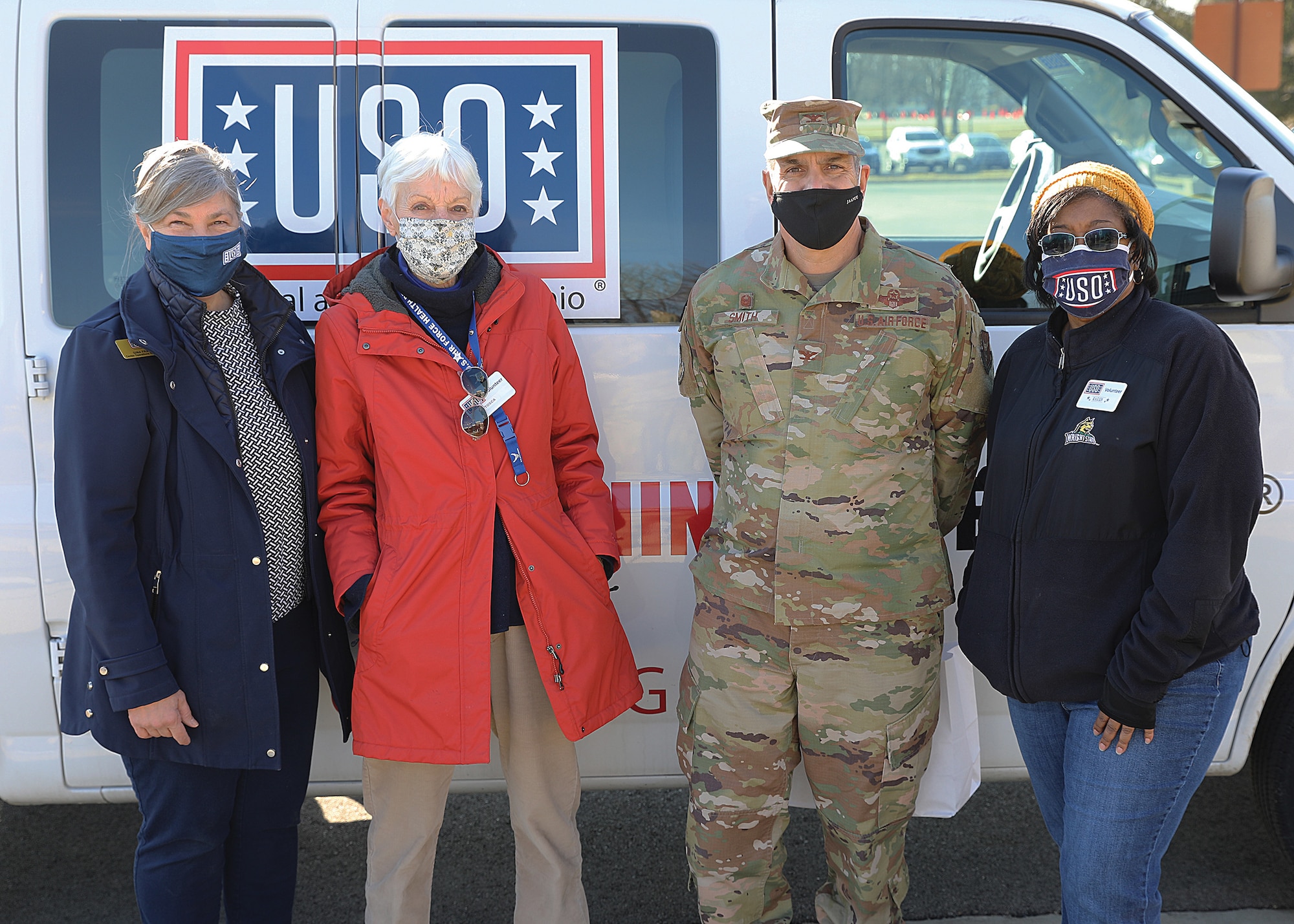 Col. Raymond Smith, 445th Airlift Wing commander, and Wright-Patterson United Service Organizations (USO) center operations specialist Gina Franz and volunteers Tosca Hallock and Karen Hunt pose for a photo Jan. 9, 2021.