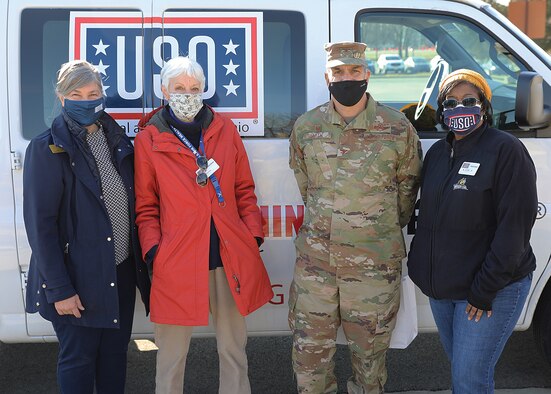 Col. Raymond Smith, 445th Airlift Wing commander, and Wright-Patterson United Service Organizations (USO) center operations specialist Gina Franz and volunteers Tosca Hallock and Karen Hunt pose for a photo Jan. 9, 2021.