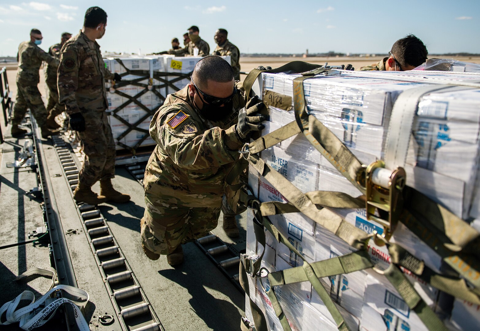U.S. Air Force Airmen and Army Soldiers unload pallets of bottled water Feb. 21 at Joint Base San Antonio-Kelly Field. Joint Base San Antonio provided emergency response assistance to local officials and agencies in order to ensure the safety and security of the community during and after the severe winter storm.