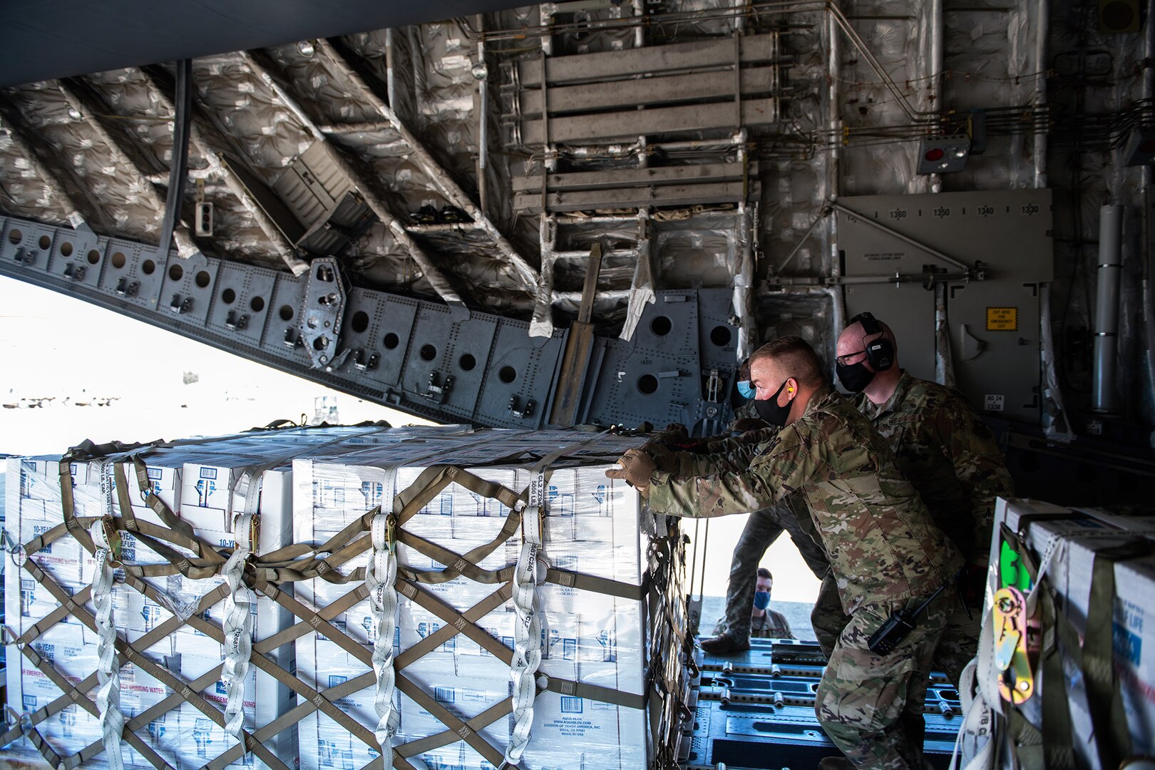 Airmen with the 502nd Logistics Readiness Squadron assist with the coordinating and unloading of more than 57,000 bottled water on a C-17 from the 16th Airlift Squadron, Joint Base Charleston, South Carolina Feb. 21 at Joint Base San Antonio-Kelly Field. The 502nd LRS assisted with the coordinating and unloading of more than 150,000 pounds of bottled water brought in via aircraft to be distributed to the city of San Antonio.