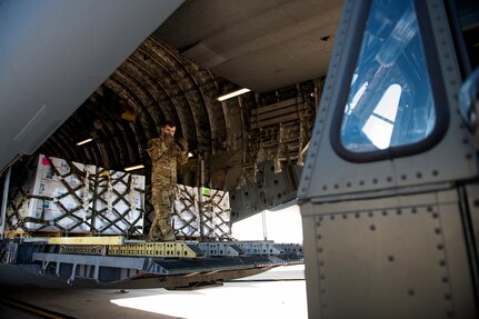 Airman 1st Class Bryce Elzy, 16th Airlift Squadron loadmaster, directs a 502nd Logistics Readiness Squadron driver Feb. 21 at Joint Base San Antonio-Kelly Field Annex. The 502nd LRS assisted with the coordinating and unloading of more than 150,000 pounds of bottled water brought in via aircraft to be distributed to the city of San Antonio.