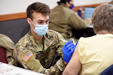 U.S. Army Spc. Lucas Tratechaud, a combat medic with 3rd Battalion, 126th Infantry Regiment, Headquarters and Headquarters Company, Michigan Army National Guard,  vaccinates a resident in Coldwater, Michigan, Feb. 18, 2021.