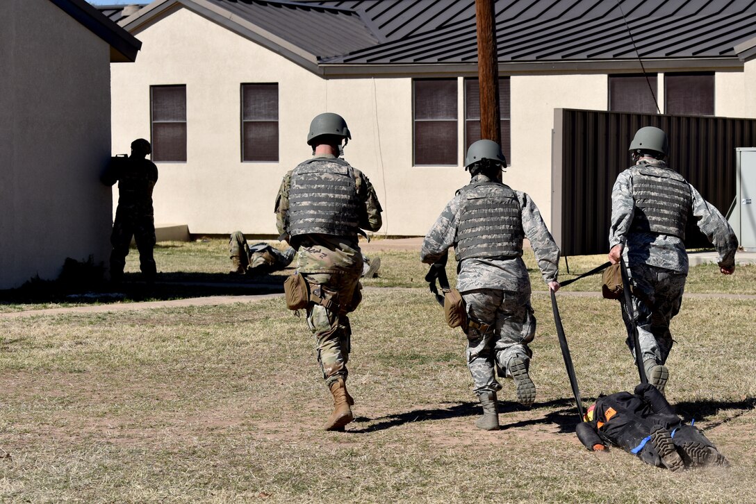 Participants drag a mannequin back to a designated safety zone during the Tactical Combat Casualty Care course training simulation behind the Airman and Family Readiness Center on Goodfellow Air Force Base, Texas, Feb. 7, 2021. The TCCC course was designed to focus on medical training in the field. (U.S. Air Force photo by Staff Sgt. Seraiah Wolf)