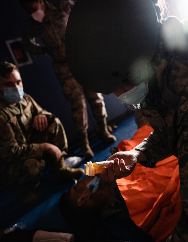 U.S. Air Force Capt. Amber Gibbons, 17th Operational Medical Readiness Squadron officer in charge of the student clinic, examines a prop prescription bottle while assessing a patient during the final exercise of the Tactical Combat Casualty Care course at the Mathis Fitness Center on Goodfellow Air Force Base, Texas, Feb. 7, 2021. During the exercise, candy was used to imitate the combat pill pack, which allowed the medics to administer the needed ‘medication’ based on simulated injuries. (U.S. Air Force photo by Senior Airman Deven Schultz)