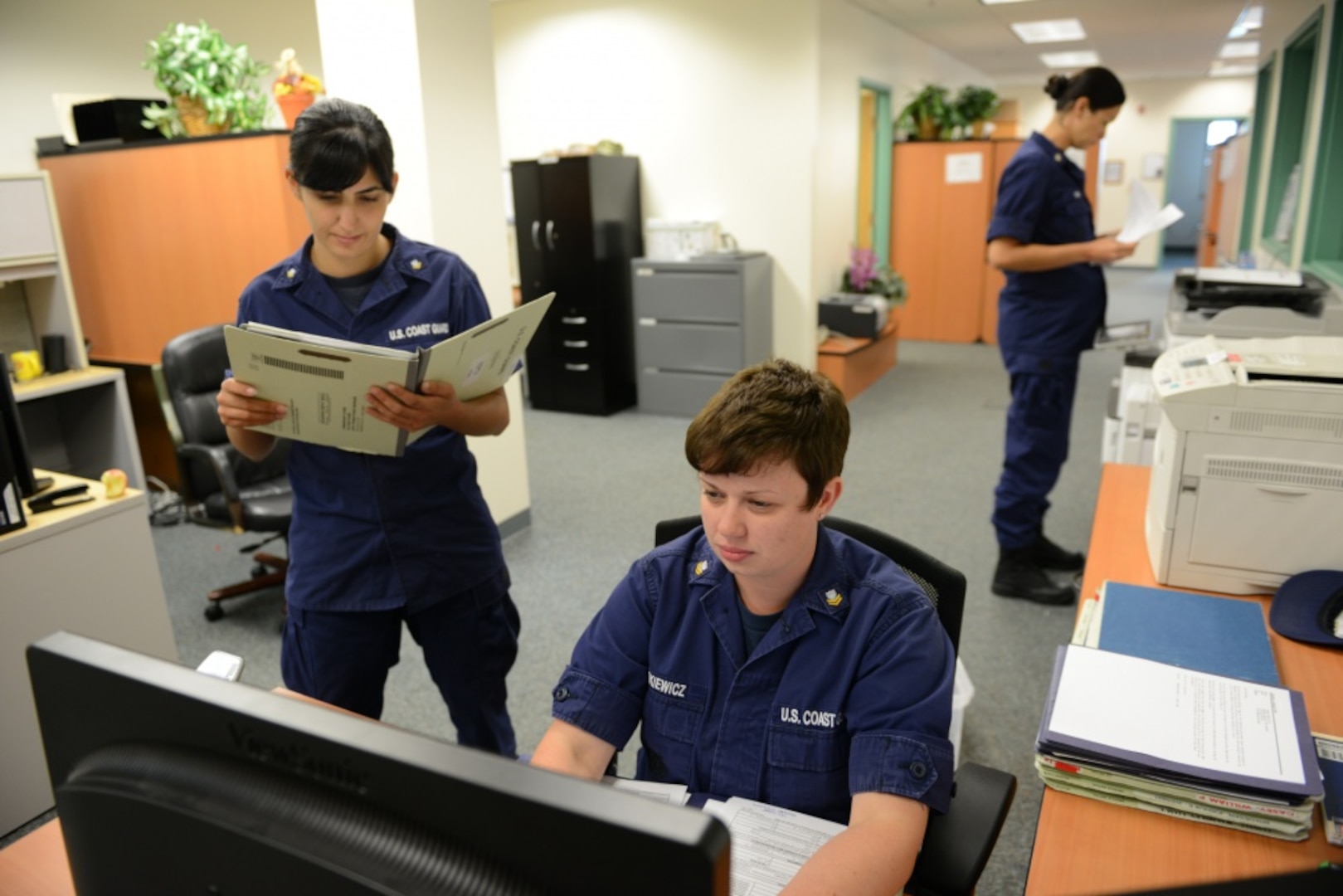 Petty Officer 2nd Class Veronica Rzotkiewicz and Petty Officer 3rd Class Daniela Abreu, yeomen at the Coast Guard Base Honolulu Servicing Personnel Office, enter data into an online Coast Guard system for crew members, Aug. 26, 2014. Yeomen are typically responsible for payroll certification and delivery; preparing military travel orders and arranging transportation, including shipment of household goods; preparing correspondence; and maintaining files and administrative records. (U.S. Coast Guard photo by Petty Officer 2nd Class Tara Molle)