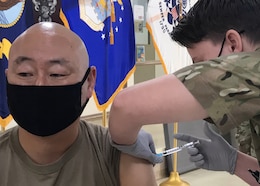Lt. Col. Harold Yu, the deputy surgeon for Area Support Group-Kuwait and the officer-in-charge of the U.S. Army Health Clinic Kuwait, looks away as he receives his second Moderna COVID-19 vaccine dose Feb. 15, 2021 at the Camp Arifjan, Kuwait hospital. Yu said: “This vaccination is no different from any other shot I ever got. Really, I didn’t even feel it.”