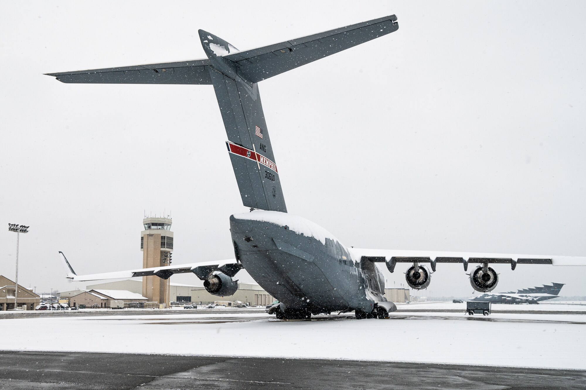 A snow-covered Tennessee Air National Guard C-17 Globemaster III sits on the flight line at Dover Air Force Base, Delaware, Feb. 11, 2021. As snow fell, the base continued normal operations and prepared for additional snowfall. (U.S. Air Force photo by Senior Airman Christopher Quail)